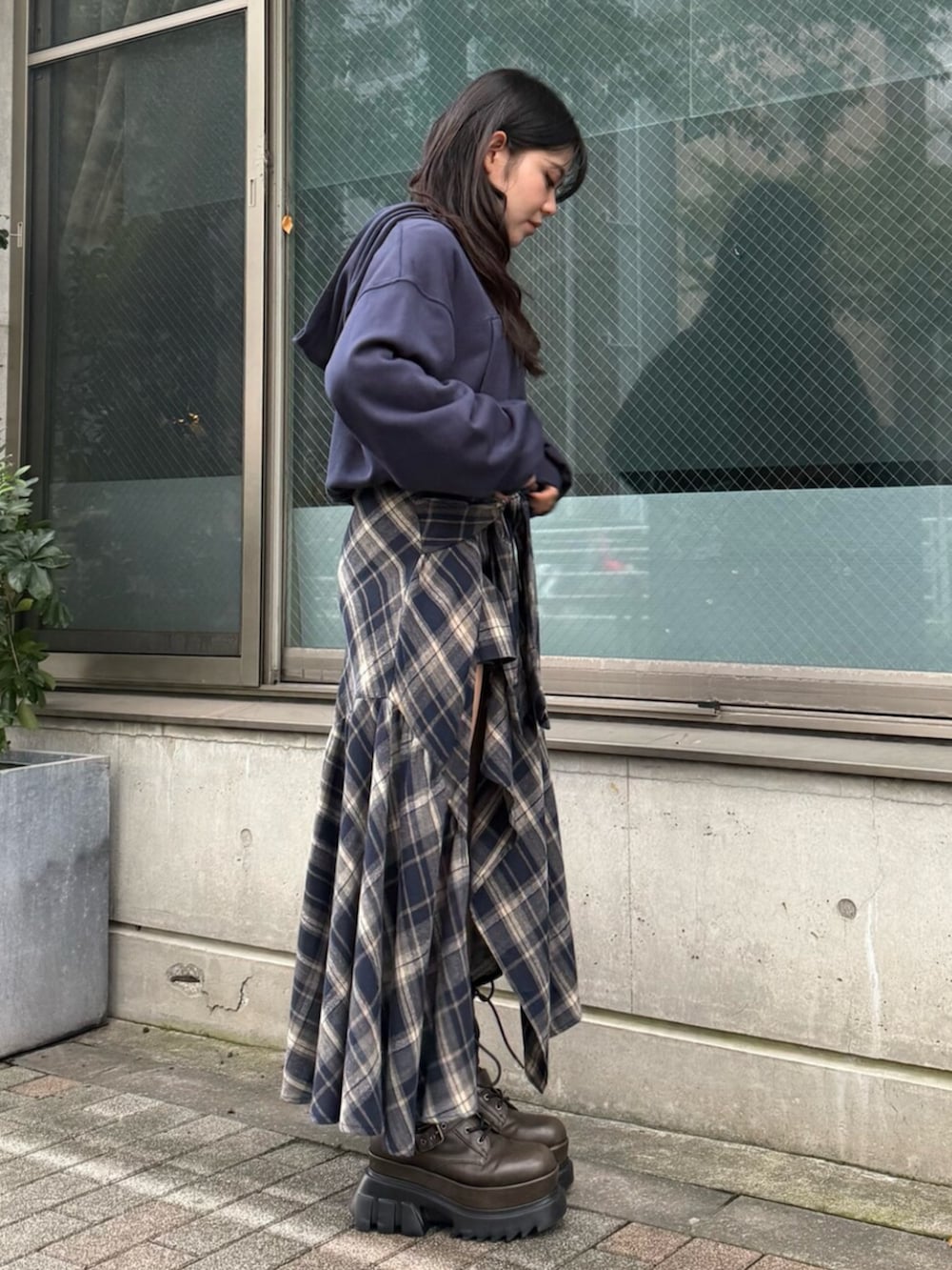 ブルー系のスカート、ブルー系のパーカー、ブラウン系のブーツを着用したレディースの秋コーディネートの2枚目の写真