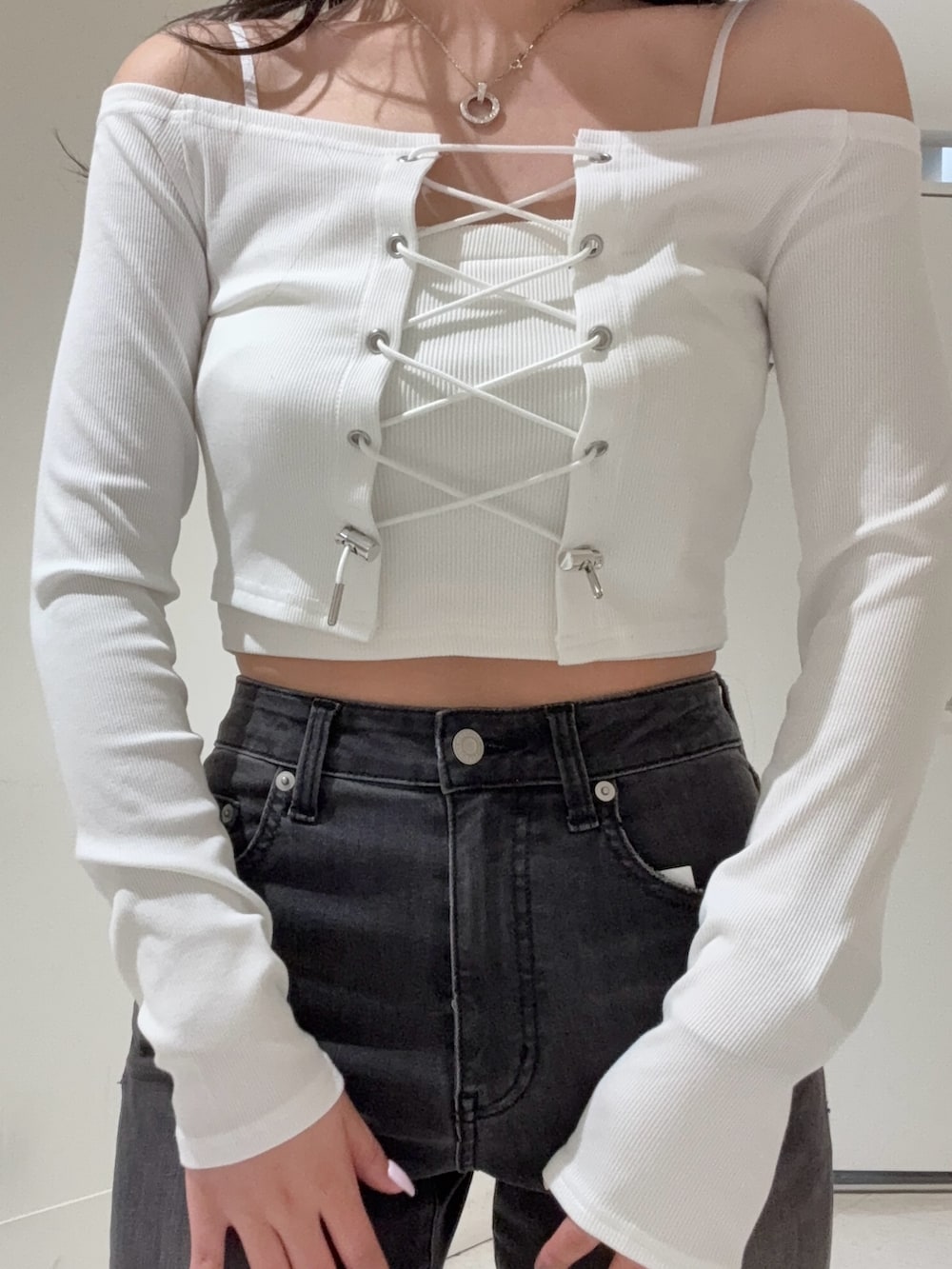 ブラック系のデニムパンツ、ホワイト系のTシャツ/カットソー、ブラック系のサンダルを着用したレディースの春コーディネートの4枚目の写真