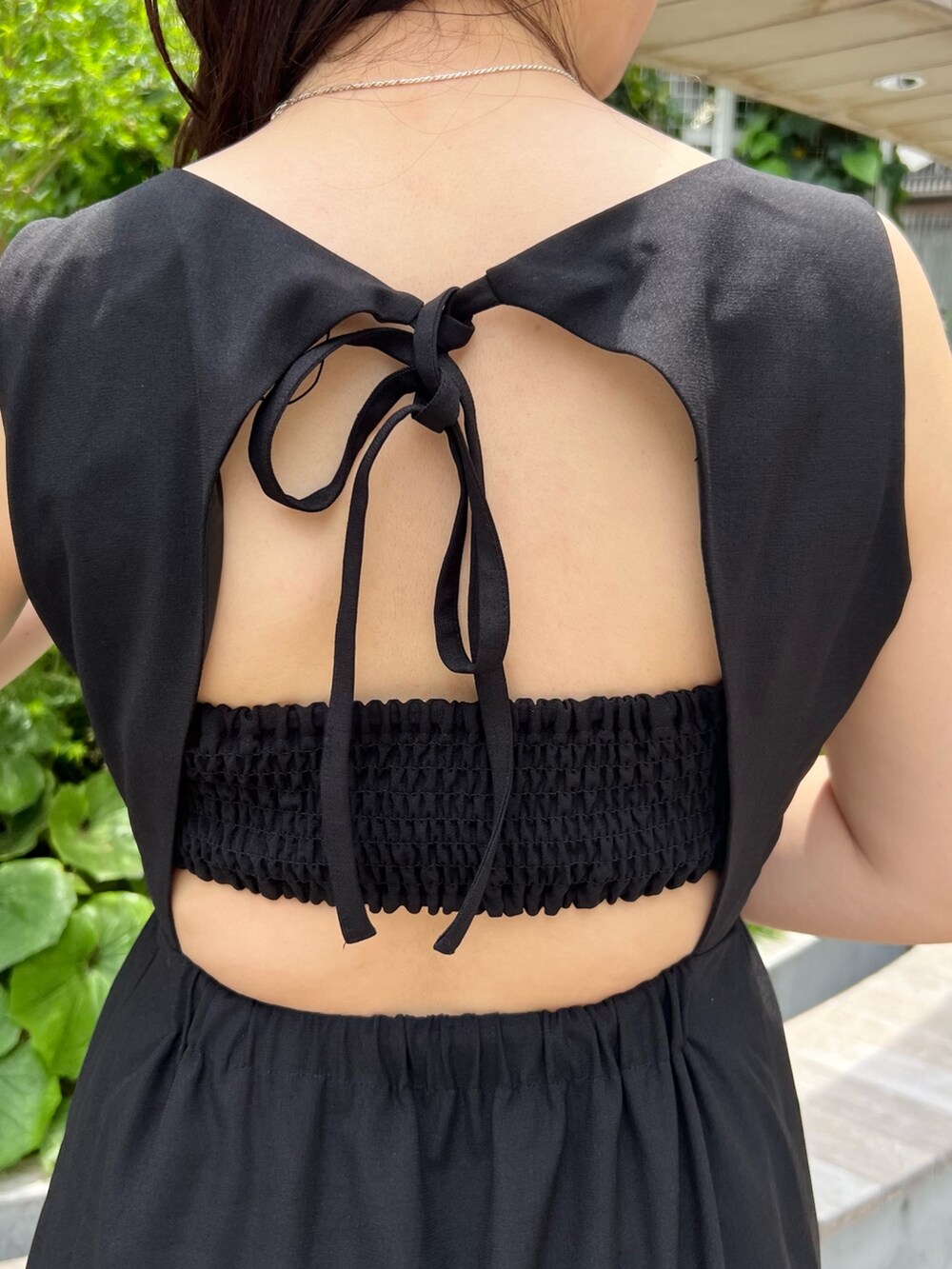 ブラック系のワンピース、ベージュ系のトートバッグ、ホワイト系のサンダルを着用したレディースの夏コーディネートの4枚目の写真