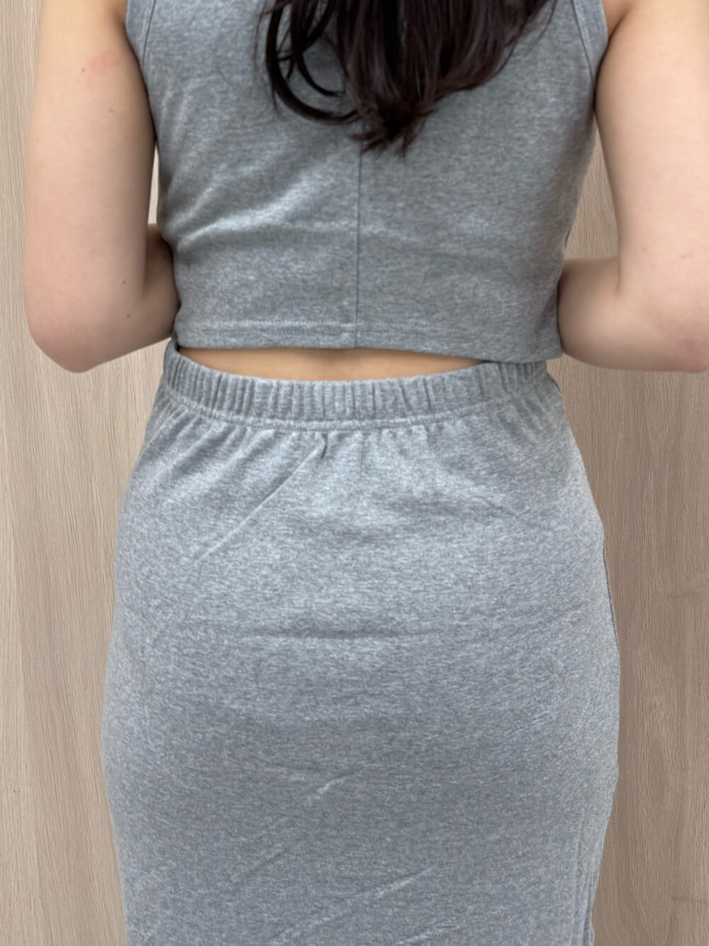 グレー系のワンピース、ブラウン系のサンダル、ブラック系のキャップを着用したレディースの春コーディネートの6枚目の写真