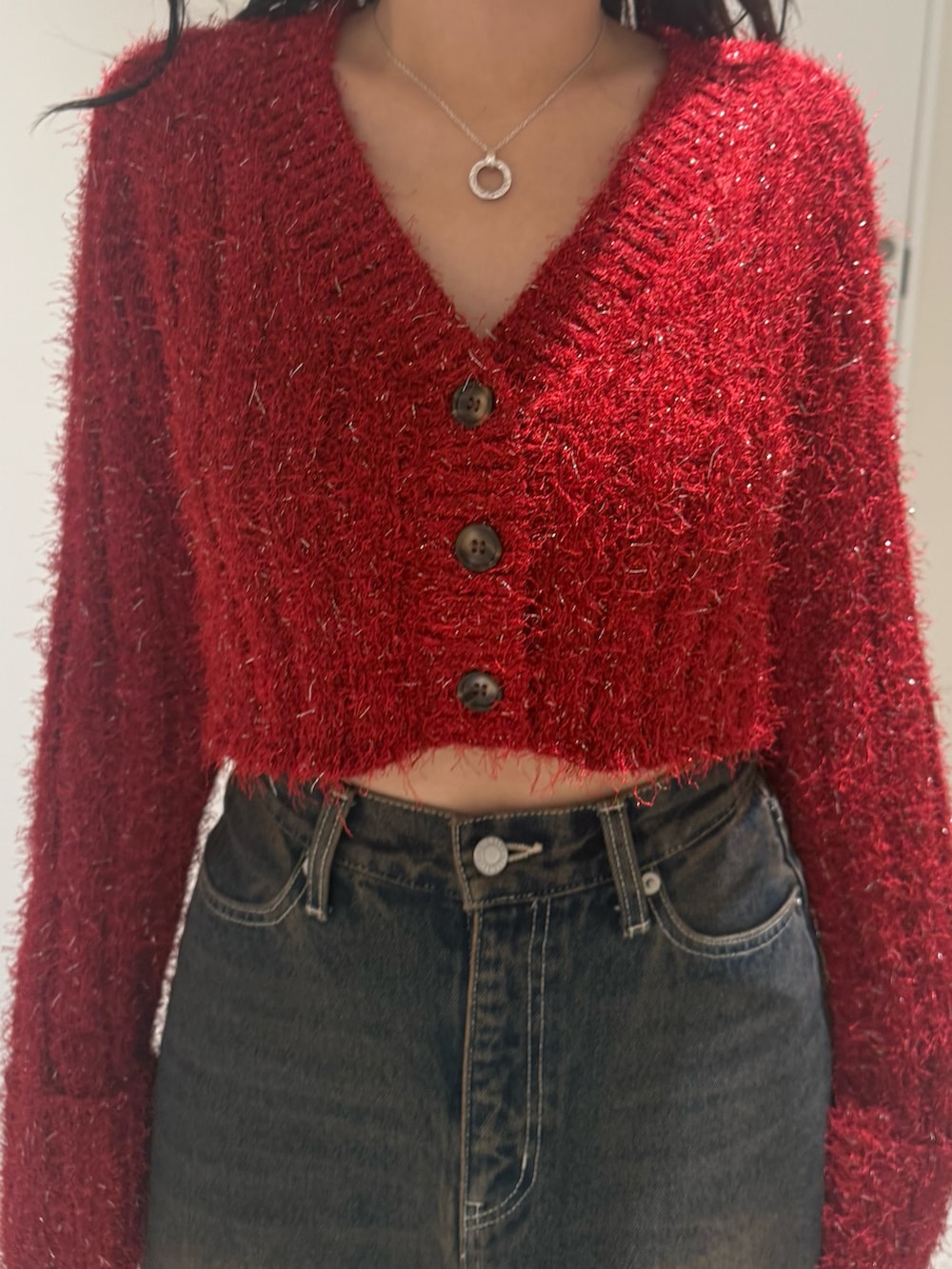 ブラック系のブーツ、ブルー系のデニムスカート、レッド系のカーディガン/ボレロを着用したレディースの秋コーディネートの4枚目の写真