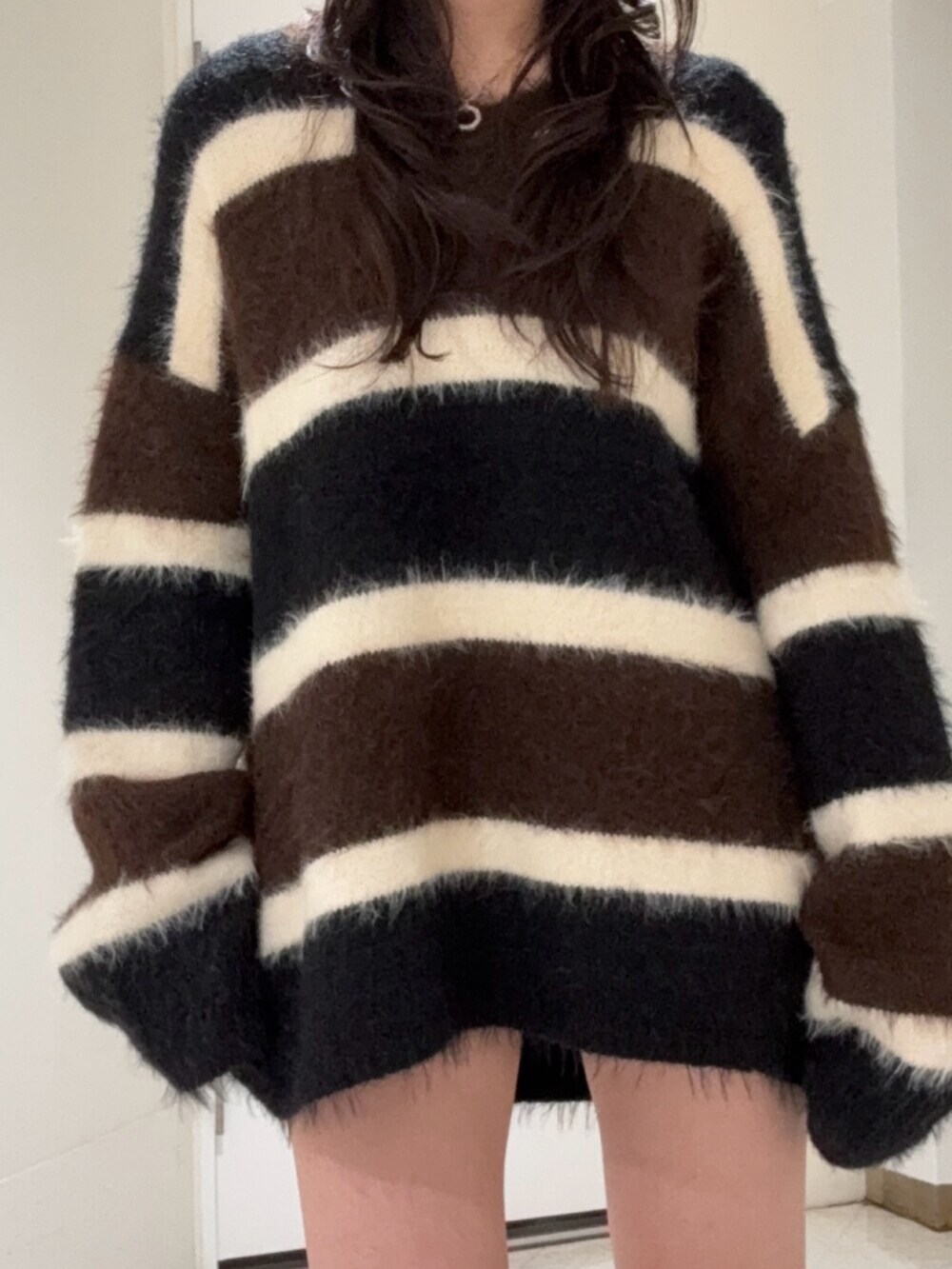 ブラック系のブーツ、ブルー系のデニムパンツ、ブラウン系のニット/セーターを着用したレディースの冬コーディネートの4枚目の写真