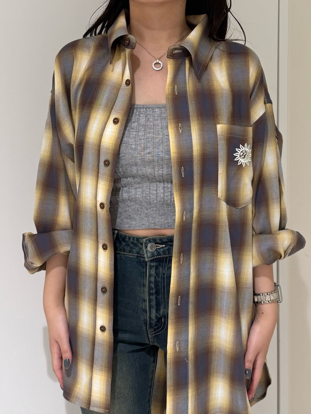 ブルー系のデニムパンツ、グレー系のニット/セーター、ブラック系のブーツを着用したレディースの夏コーディネートの4枚目の写真