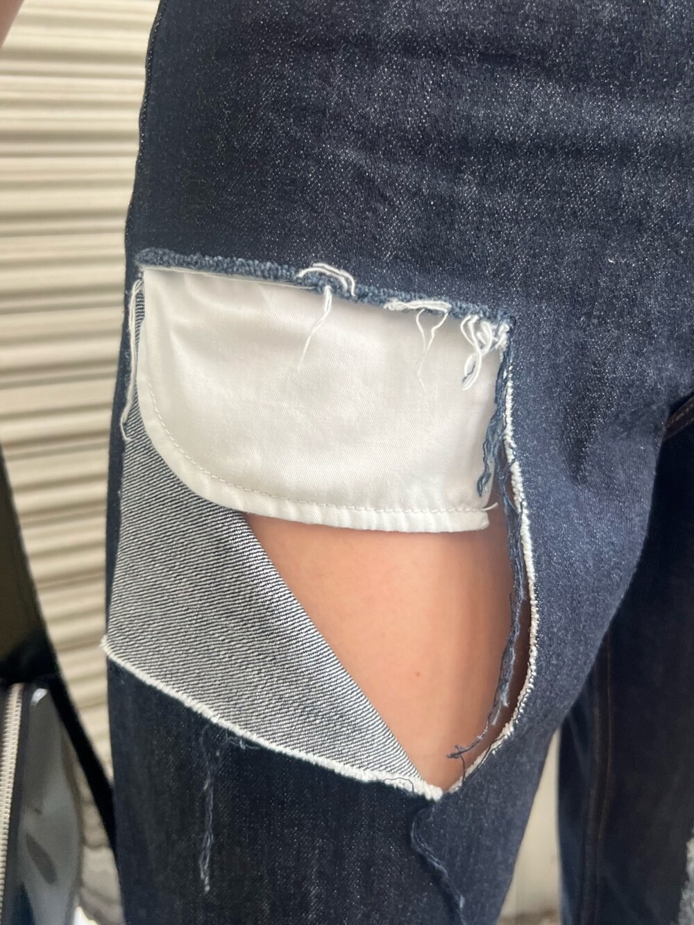 ブルー系のデニムパンツ、ホワイト系のTシャツ/カットソー、ブラック系のハンドバッグを着用したレディースの夏コーディネートの5枚目の写真