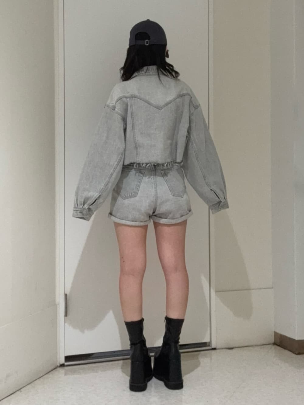 ブラック系のブーツ、グレー系のデニムパンツ、グレー系のデニムジャケットを着用したレディースの冬コーディネートの3枚目の写真