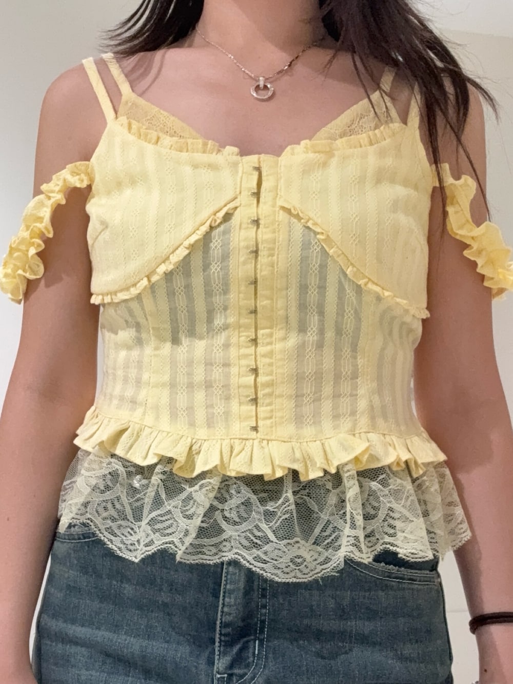 イエロー系のキャミソール、ブルー系のデニムパンツ、ブラック系のサンダルを着用したレディースの春コーディネートの4枚目の写真