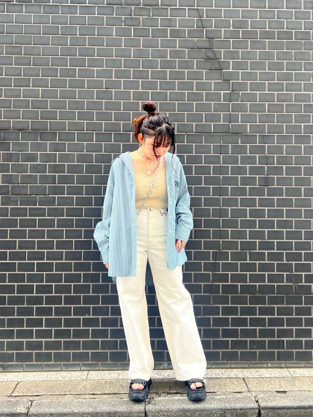 グリーン系のシャツ/ブラウス、ホワイト系のカーディガン/ボレロ、ホワイト系のデニムパンツを着用したレディースの春コーディネートの2枚目の写真