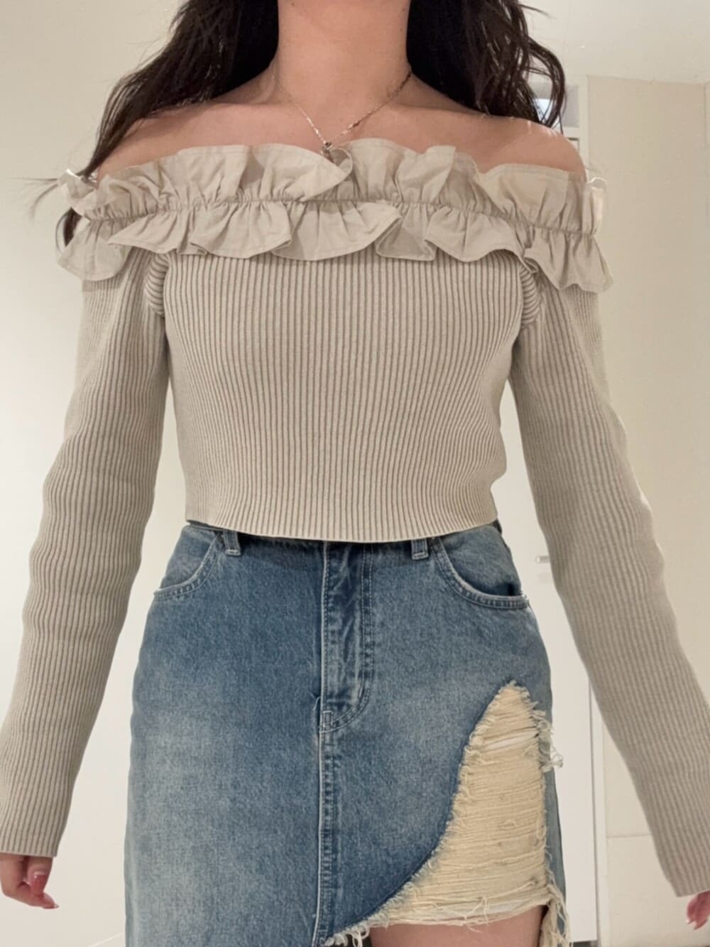 ブラック系のブーツ、ブルー系のデニムスカート、ベージュ系のニット/セーターを着用したレディースの春コーディネートの4枚目の写真