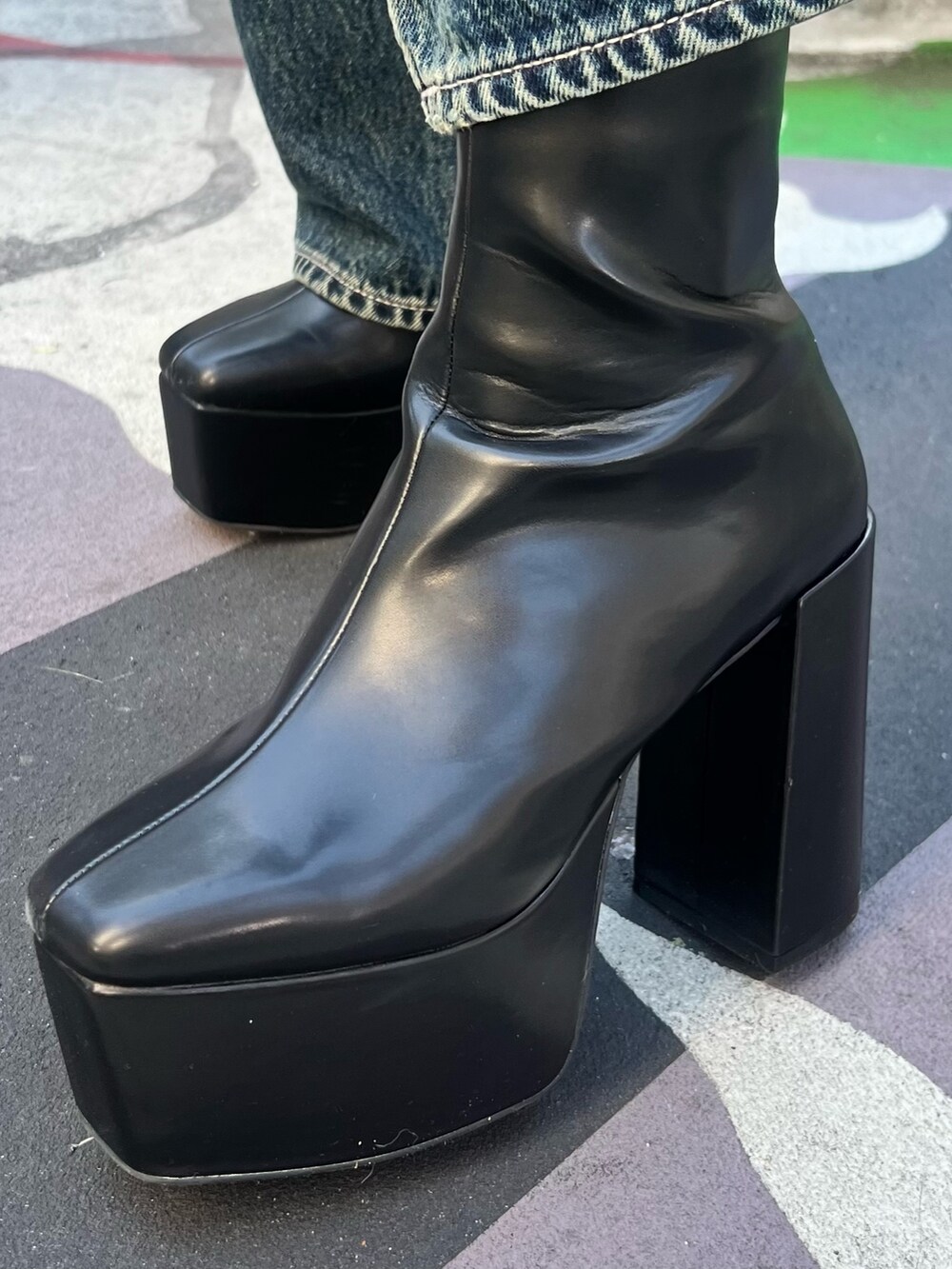 ブルー系のデニムパンツ、ブラック系のカーディガン/ボレロ、ブラック系のブーツを着用したレディースの冬コーディネートの9枚目の写真