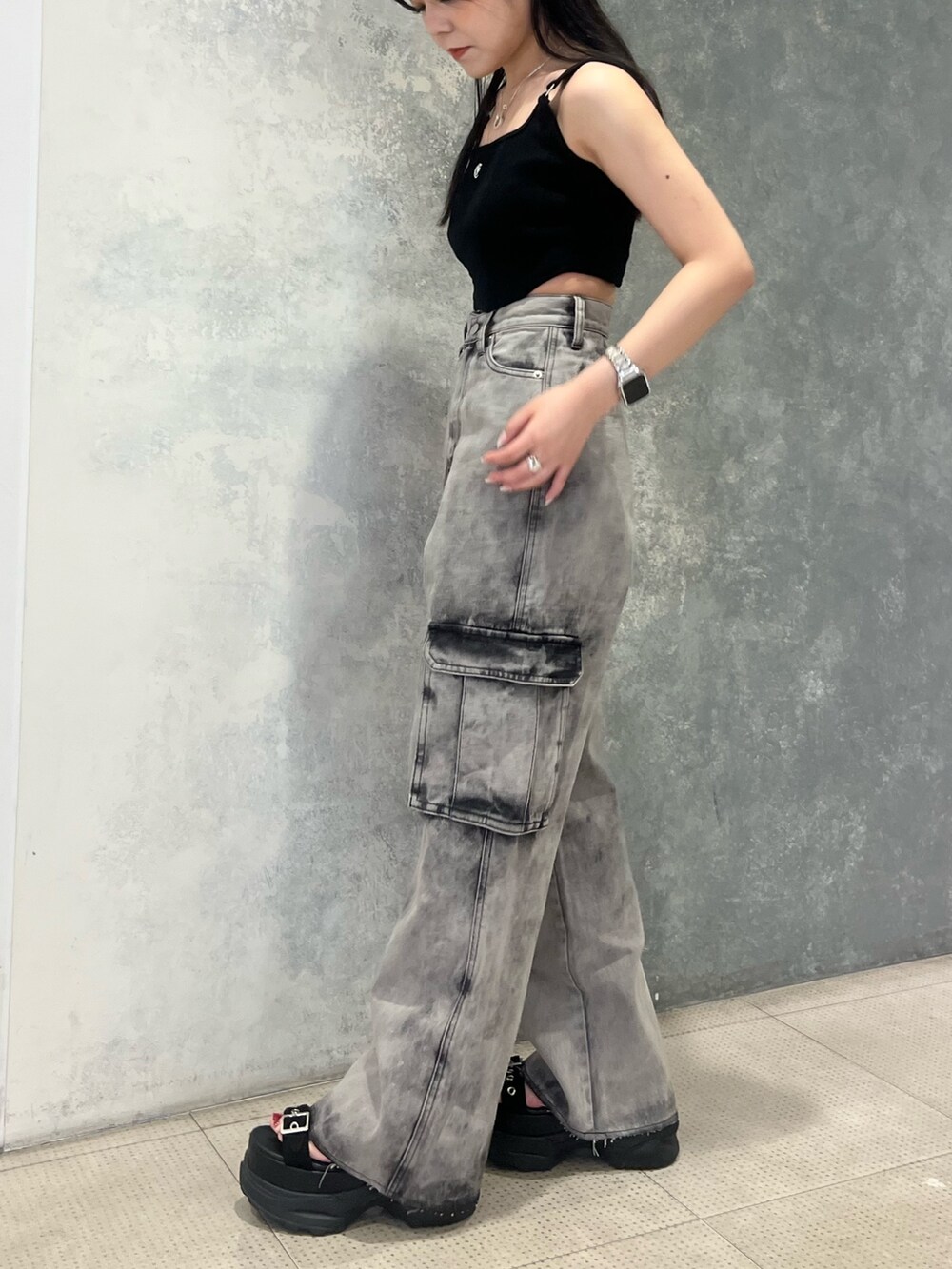 ブラック系のデニムパンツ、ブラック系のキャミソール、ブラック系のサンダルを着用したレディースの夏コーディネートの3枚目の写真