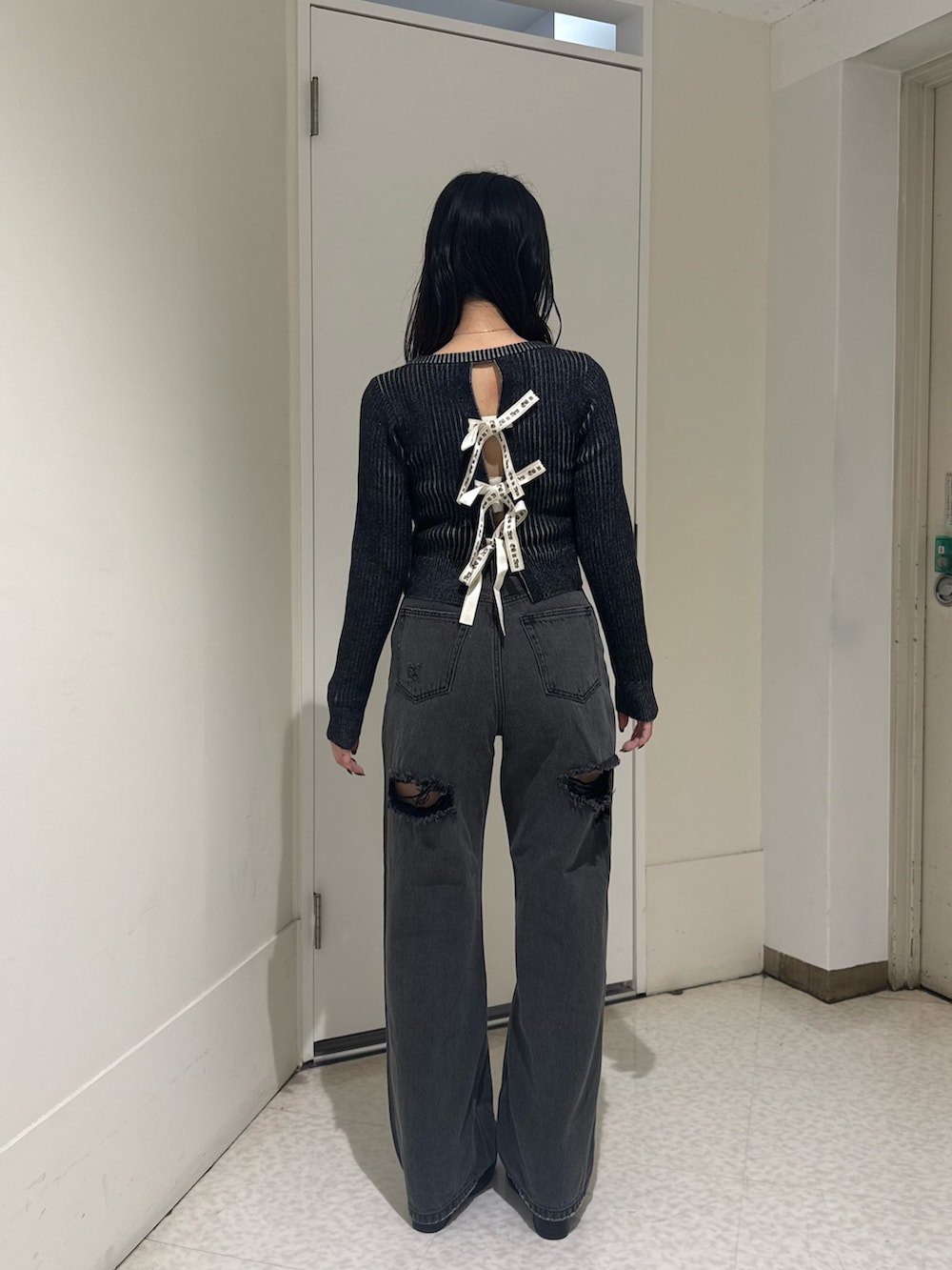 ブラック系のブーツ、ブラウン系のニット/セーター、ブラック系のデニムパンツを着用したレディースの秋コーディネートの3枚目の写真