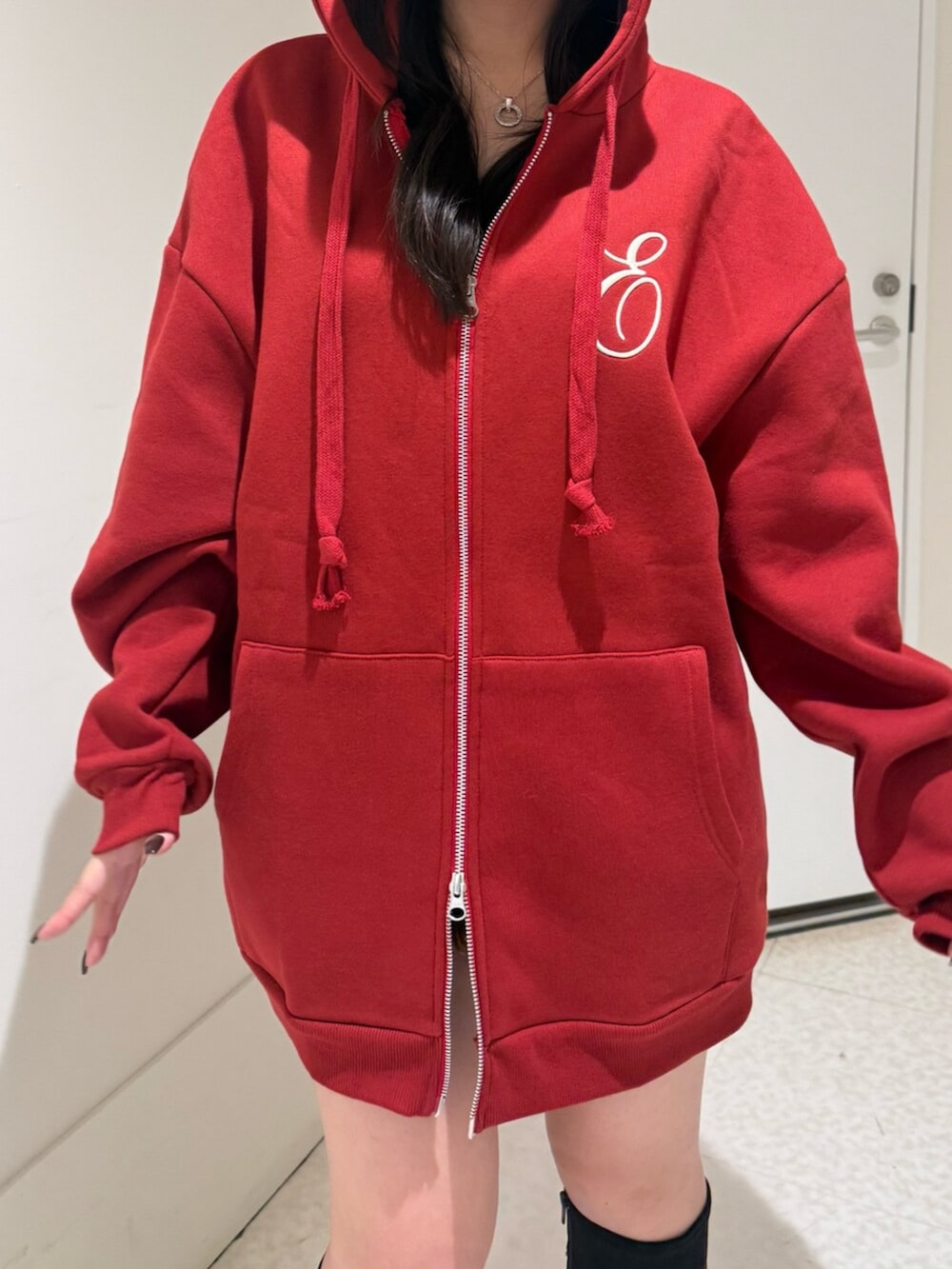 ブラック系のブーツ、レッド系のパーカーを着用したレディースの秋コーディネートの4枚目の写真