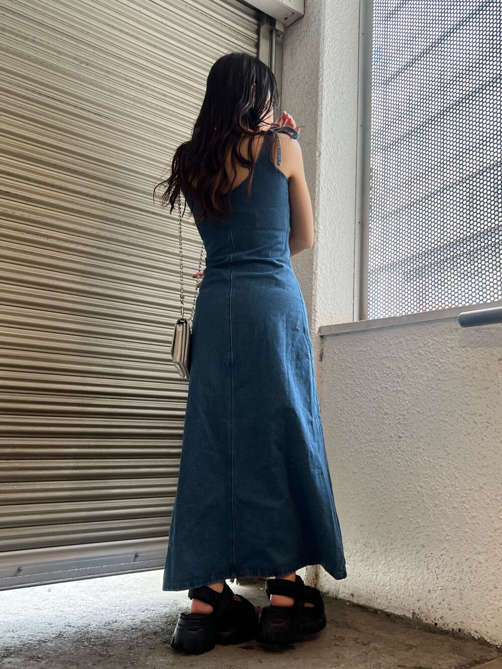 ブルー系のワンピース、ブラック系のサンダル、シルバー系のショルダーバッグを着用したレディースの春コーディネートの6枚目の写真