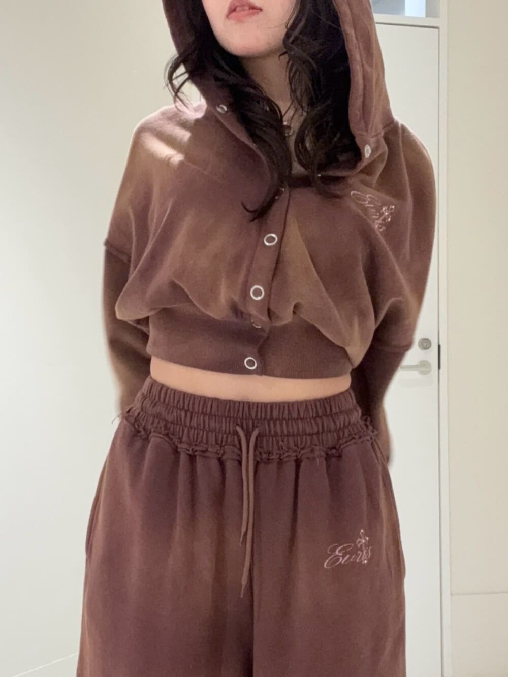 ブラウン系のパーカー、ブラウン系のスウェットパンツ、ブラウン系のサンダルを着用したレディースの冬コーディネートの4枚目の写真