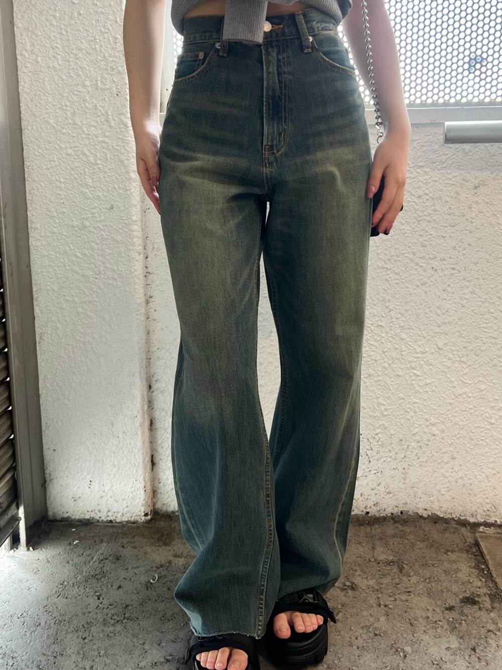 ブルー系のデニムパンツ、グレー系のキャミソール、ブラック系のショルダーバッグを着用したレディースの春コーディネートの6枚目の写真