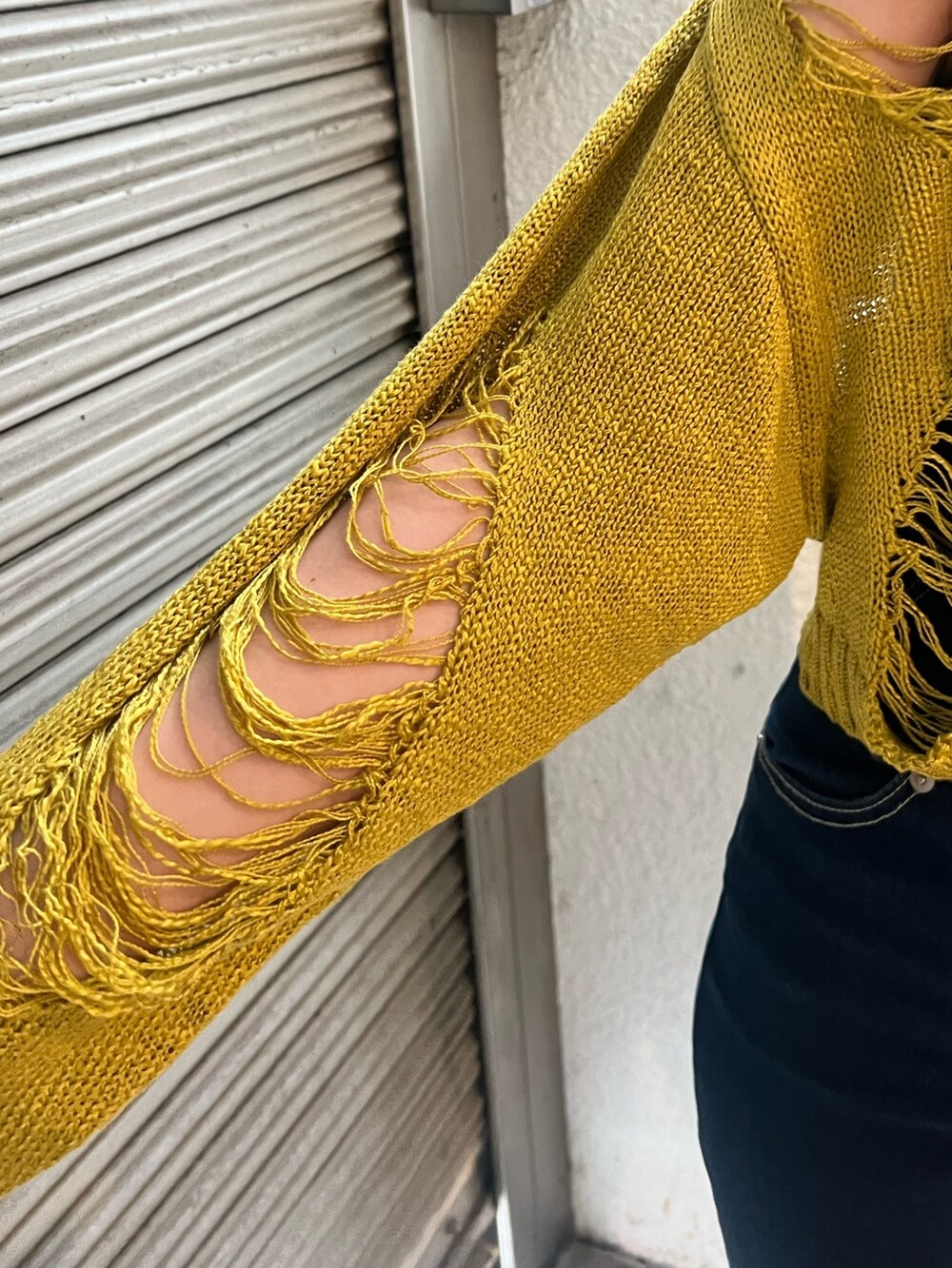 ブルー系のデニムパンツ、ブラック系のサンダル、ブラック系のハンドバッグを着用したレディースの春コーディネートの5枚目の写真