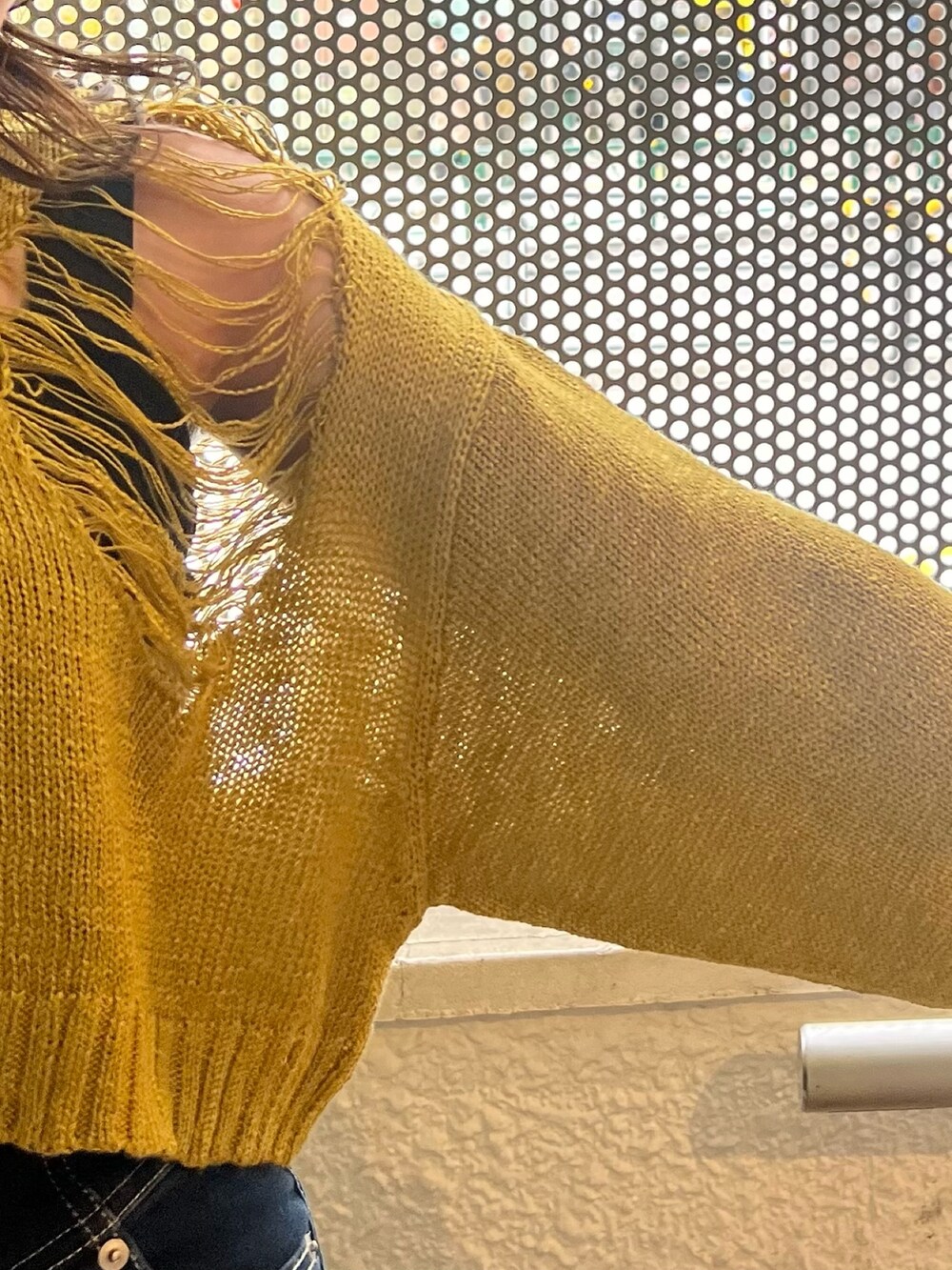 ブルー系のデニムパンツ、ブラック系のサンダル、ブラック系のハンドバッグを着用したレディースの春コーディネートの4枚目の写真