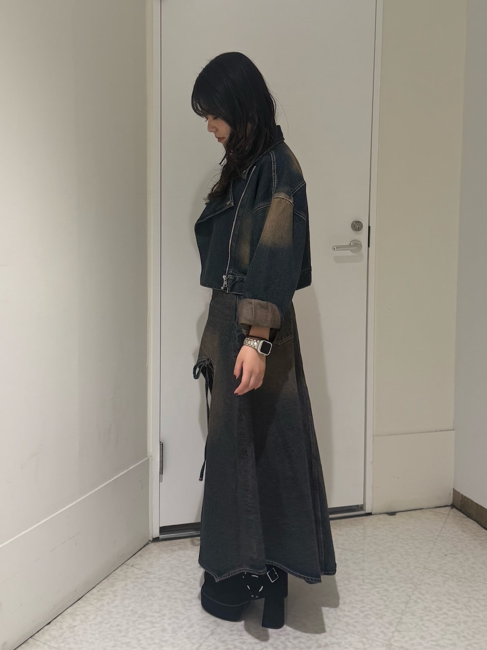 ブラック系のブーツ、ブルー系のデニムスカート、ブルー系のデニムジャケットを着用したレディースの秋コーディネートの2枚目の写真