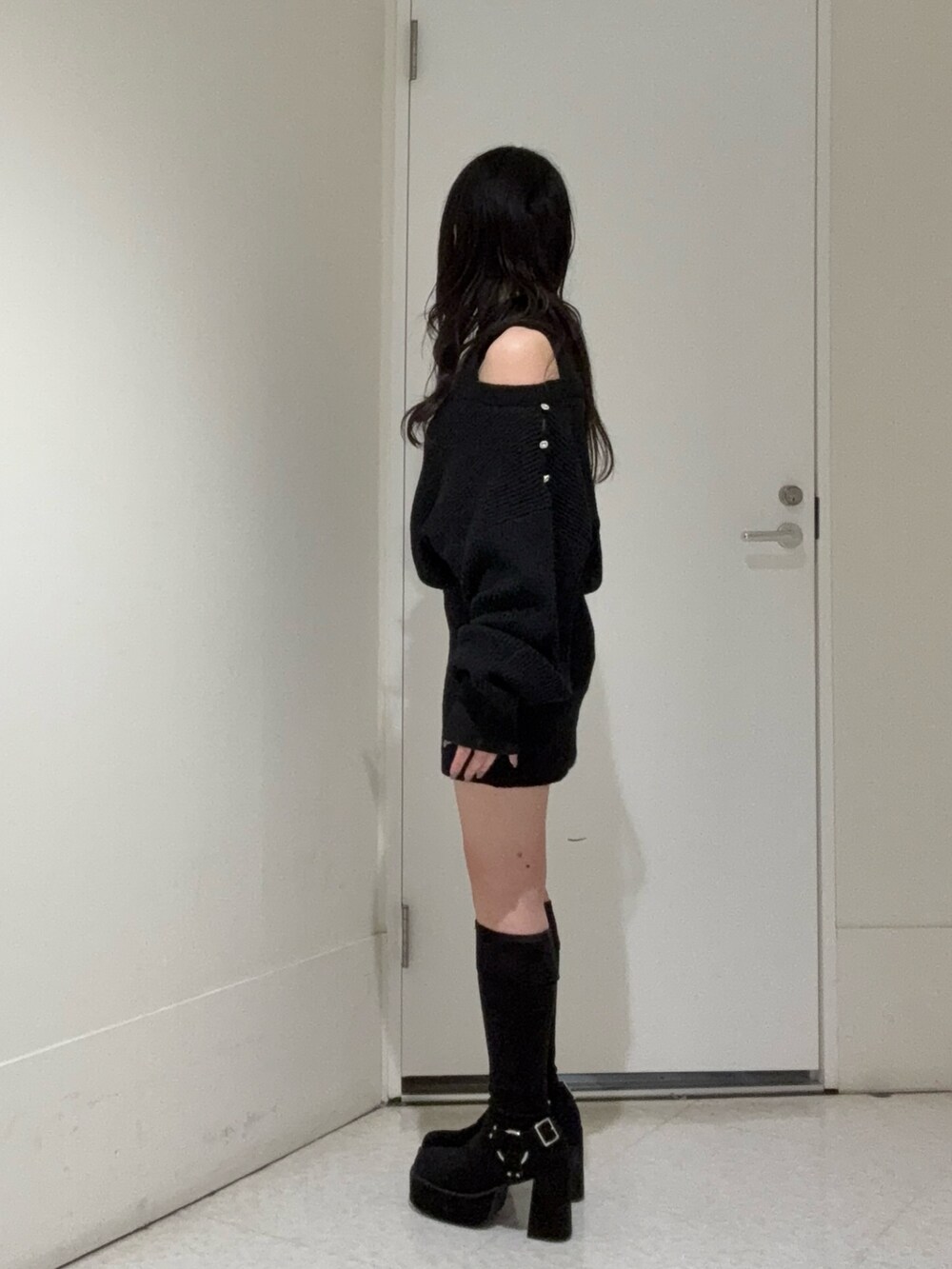 ブラック系のワンピース、ブラック系のブーツを着用したレディースの冬コーディネートの2枚目の写真