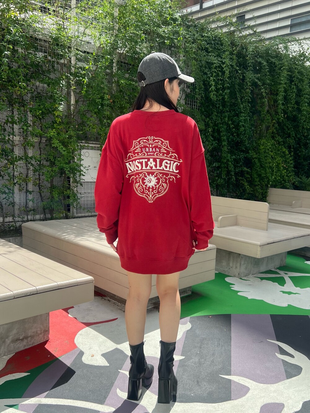 レッド系のスウェット、ブラック系のショルダーバッグ、ブラック系のブーツを着用したレディースの夏コーディネートの4枚目の写真