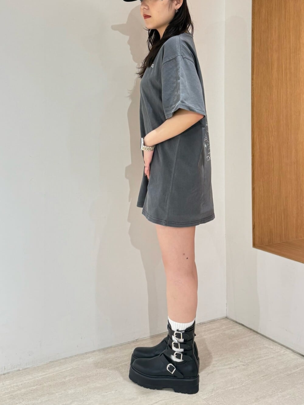 ブラック系のブーツ、ブラック系のTシャツ/カットソー、ブラック系のキャップを着用したレディースの春コーディネートの2枚目の写真