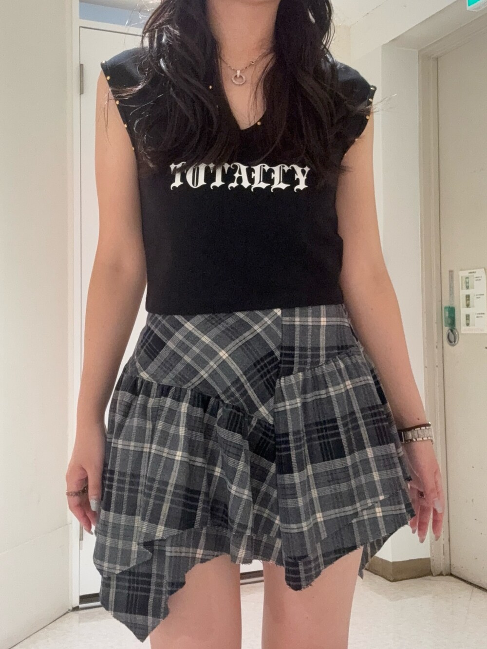 ブラック系のスカート、ブラック系のタンクトップ、ブラウン系のサンダルを着用したレディースの夏コーディネートの4枚目の写真