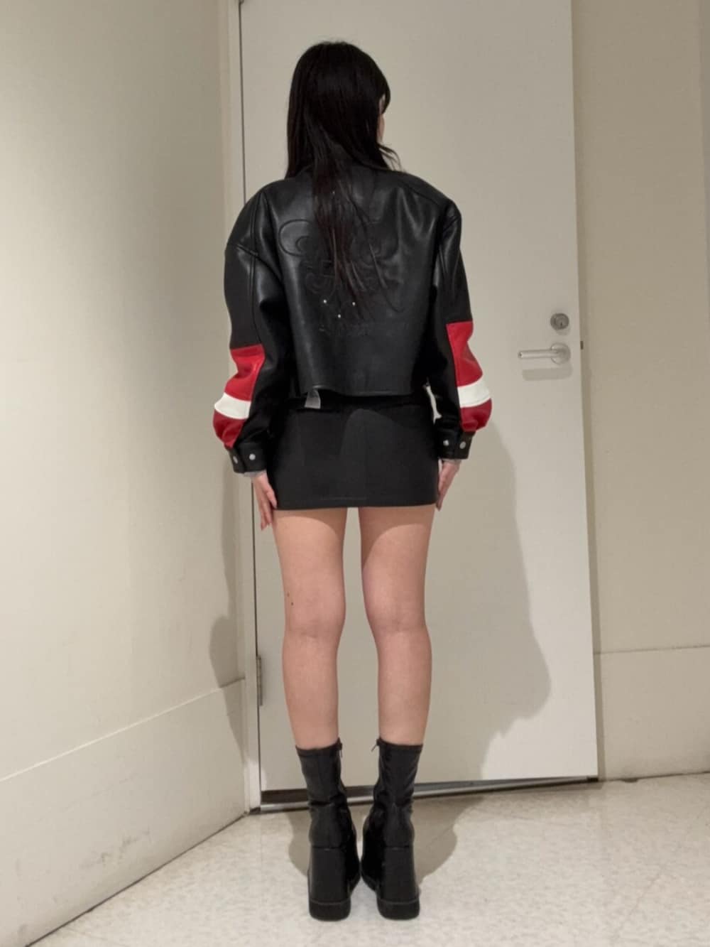 ブラック系のブーツ、ブラック系のスカート、その他のブルゾンを着用したレディースの冬コーディネートの3枚目の写真