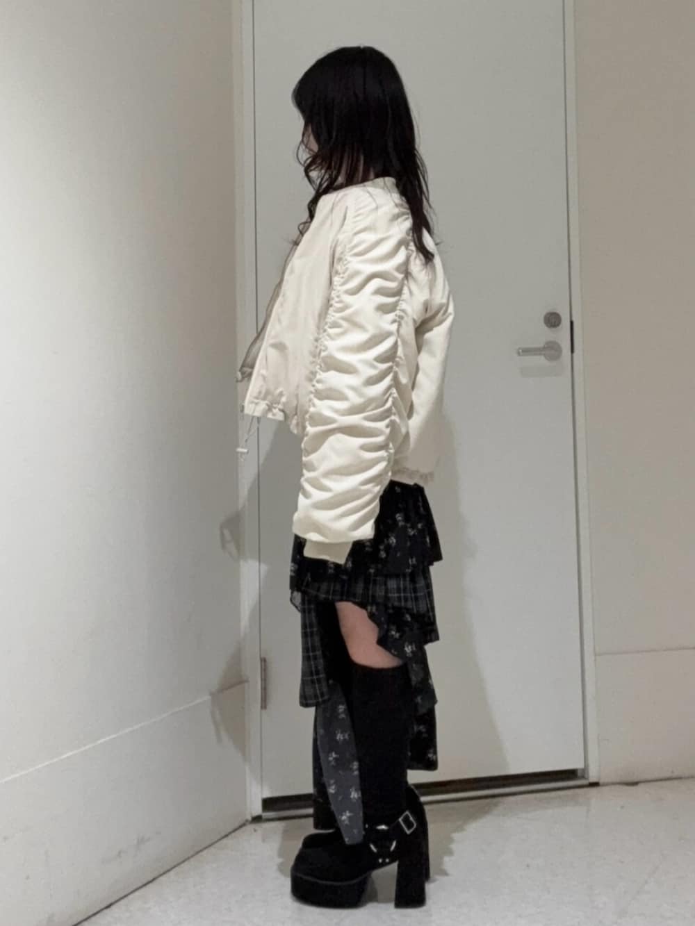 ブラック系のブーツ、ホワイト系のMA-1、その他のスカートを着用したレディースの冬コーディネートの2枚目の写真