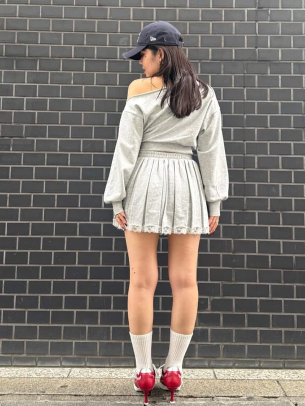 レッド系のパンプス、グレー系のスウェット、グレー系のスカートを着用したレディースの春コーディネートの3枚目の写真