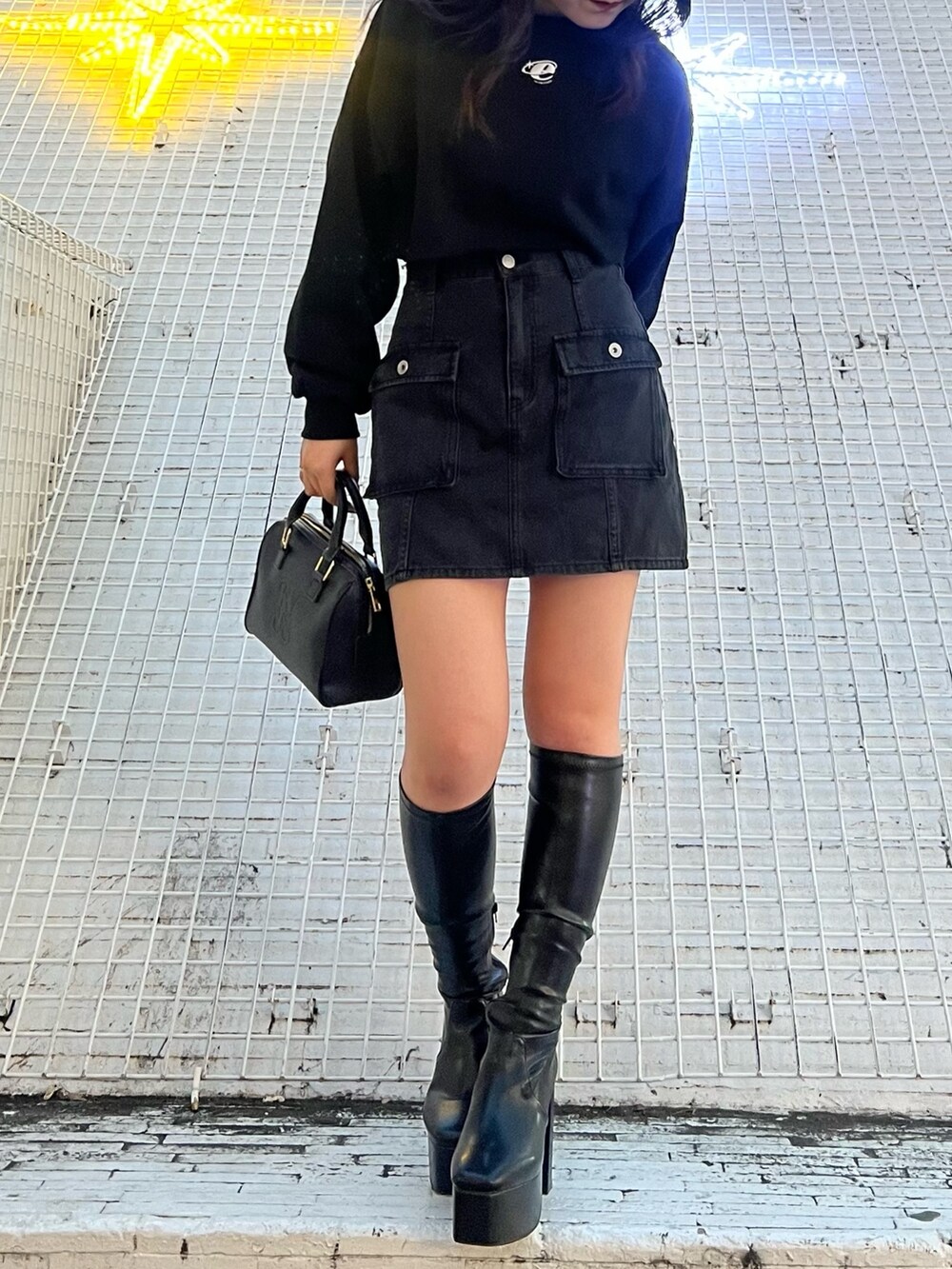 ブラック系のブーツ、ブラック系のデニムスカート、ブラック系のスウェットを着用したレディースの冬コーディネートの4枚目の写真