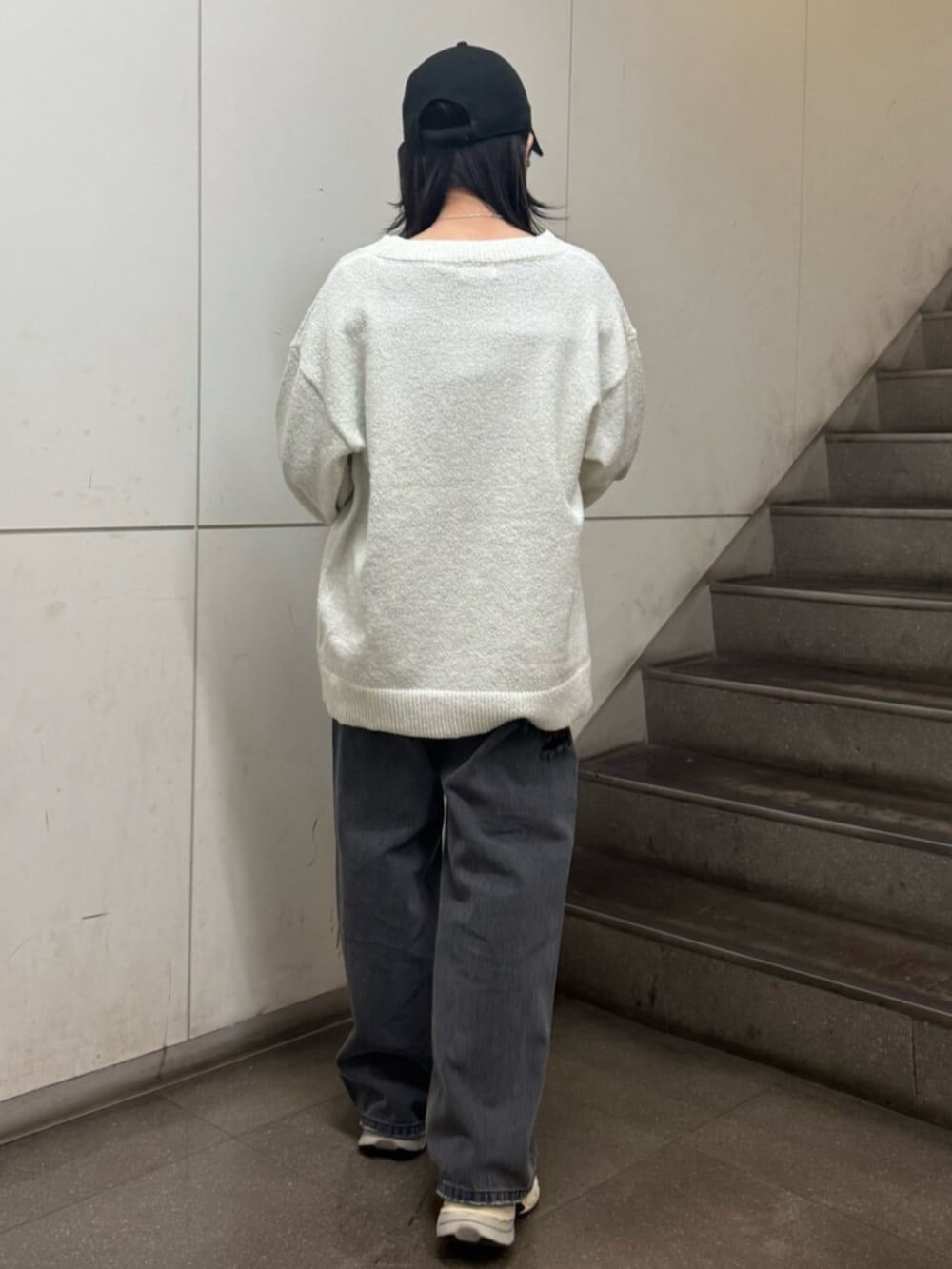 グレー系のニット/セーター、ホワイト系のカーディガン/ボレロ、ブラック系のデニムパンツを着用したレディースの春コーディネートの4枚目の写真