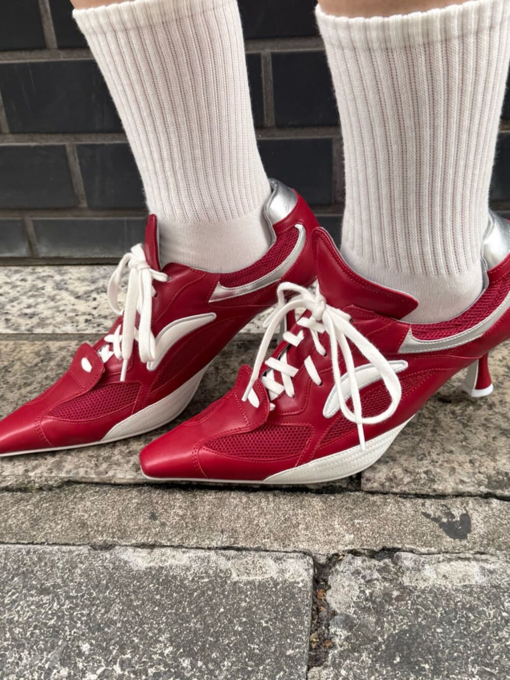 レッド系のパンプス、グレー系のスウェット、グレー系のスカートを着用したレディースの春コーディネートの6枚目の写真