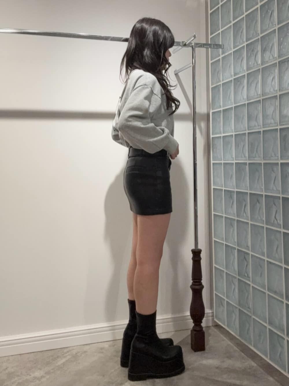 ブラック系のブーツ、ブラック系のスカート、グレー系のスウェットを着用したレディースの冬コーディネートの2枚目の写真