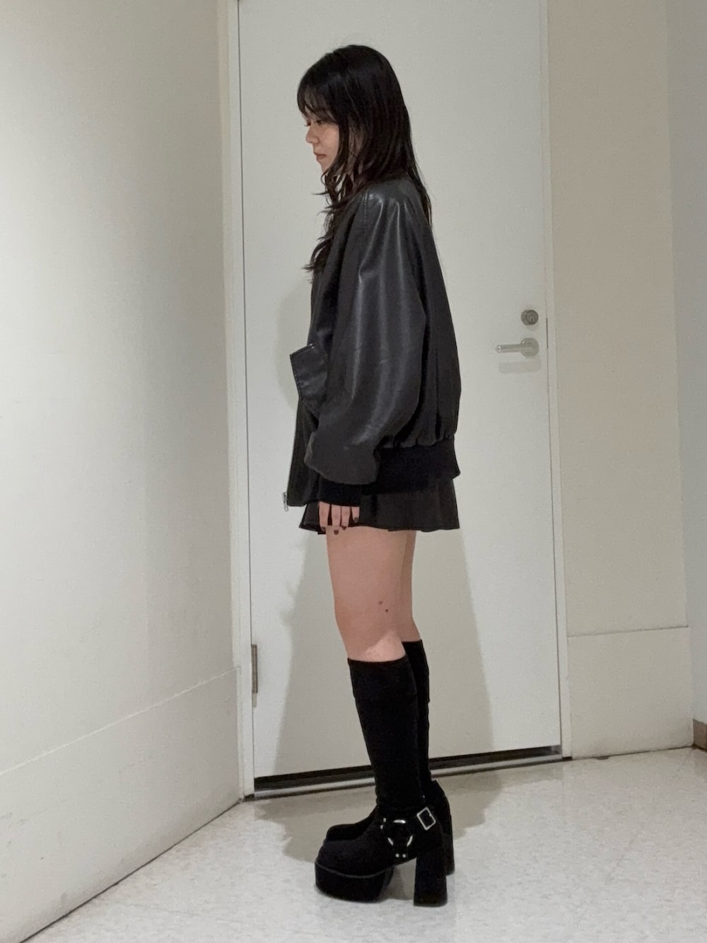 ブラック系のスカート、ブラック系のブーツ、ブラック系のブルゾンを着用したレディースの秋コーディネートの2枚目の写真