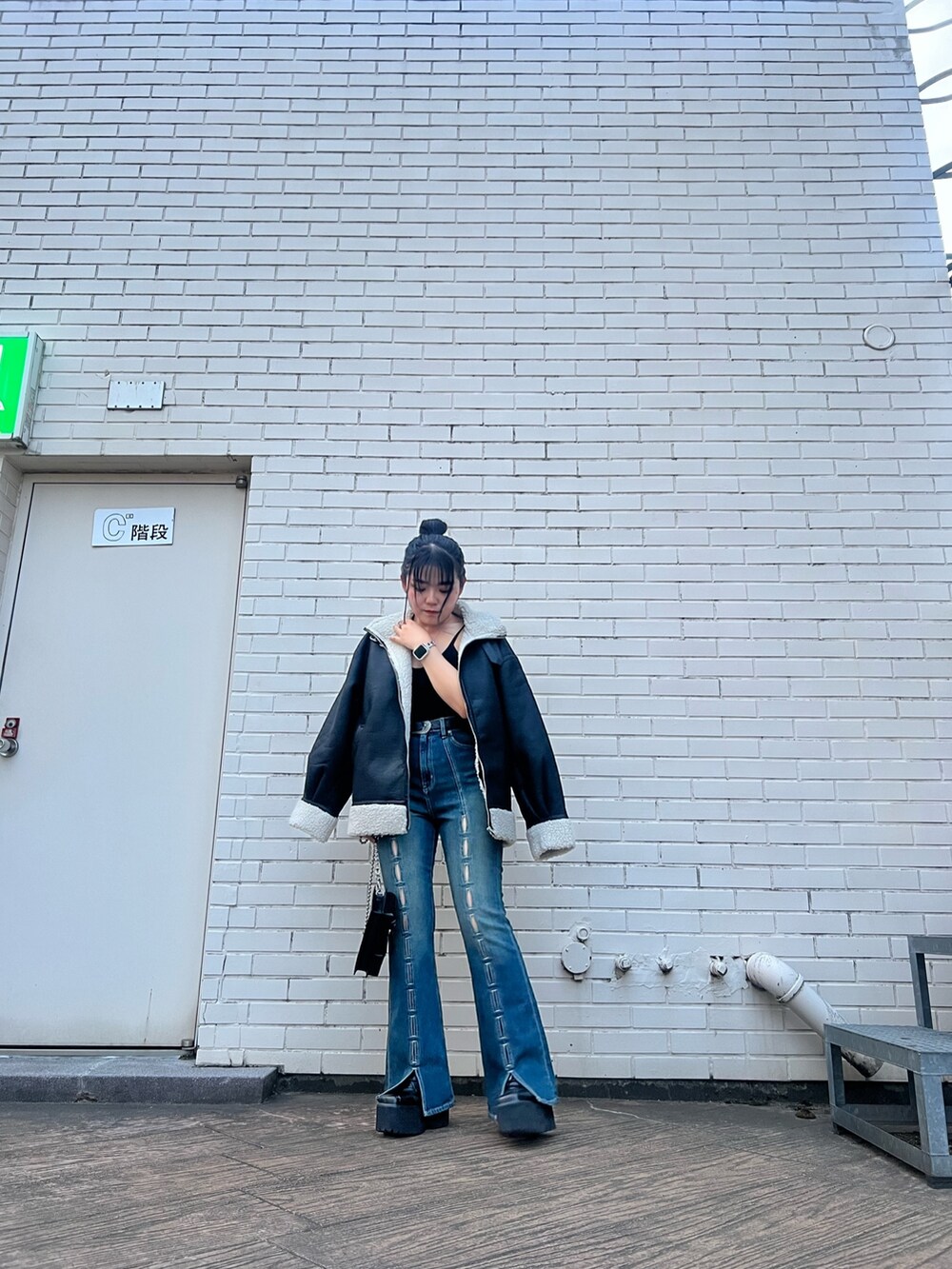 その他のムートンコート、ブルー系のデニムパンツ、ブラック系のショルダーバッグを着用したレディースの夏コーディネートの2枚目の写真