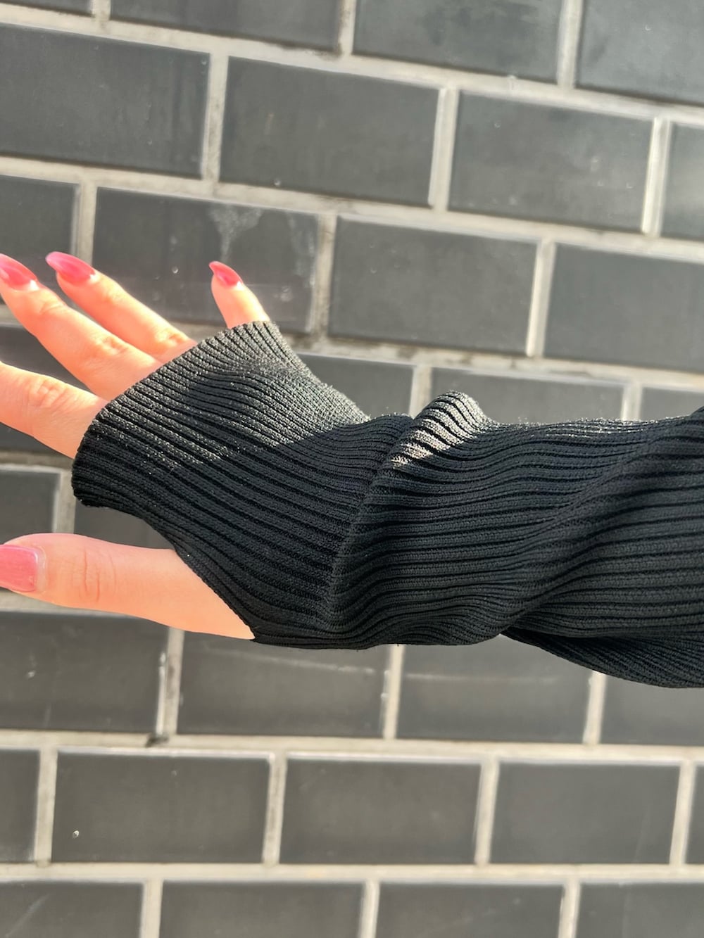 ブルー系のデニムパンツ、ブラック系のニット/セーター、ブラック系のサンダルを着用したレディースの春コーディネートの6枚目の写真