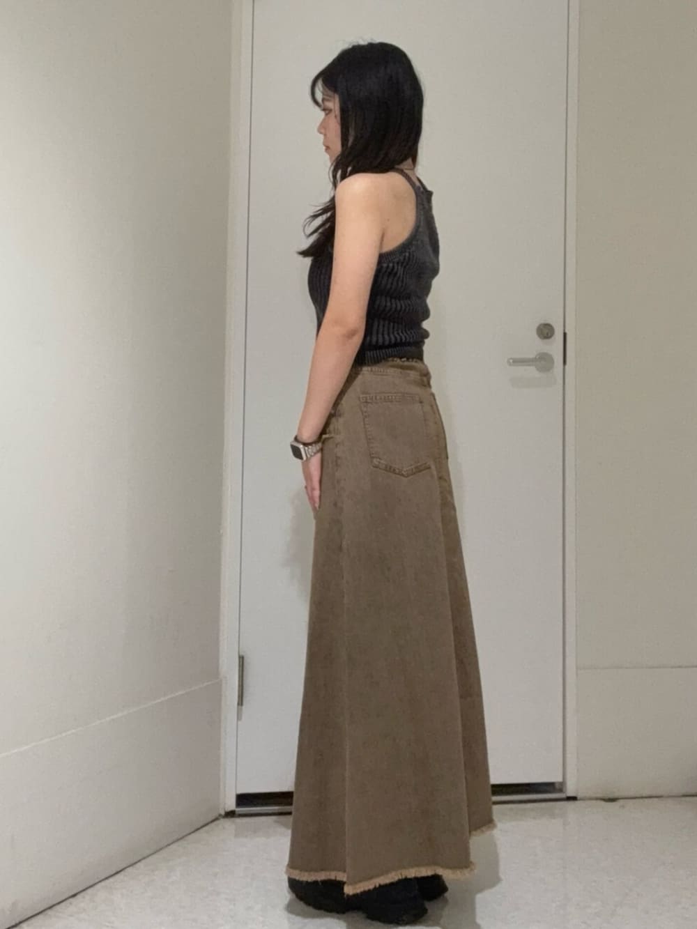 ブラウン系のサンダル、ブルー系のデニムスカート、ブラック系のニット/セーターを着用したレディースの夏コーディネートの2枚目の写真