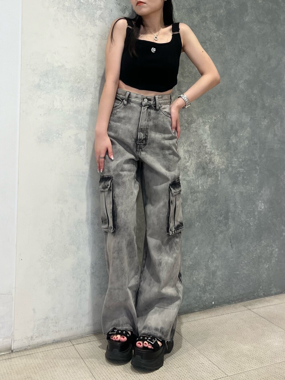 ブラック系のデニムパンツ、ブラック系のキャミソール、ブラック系のサンダルを着用したレディースの夏コーディネートの2枚目の写真