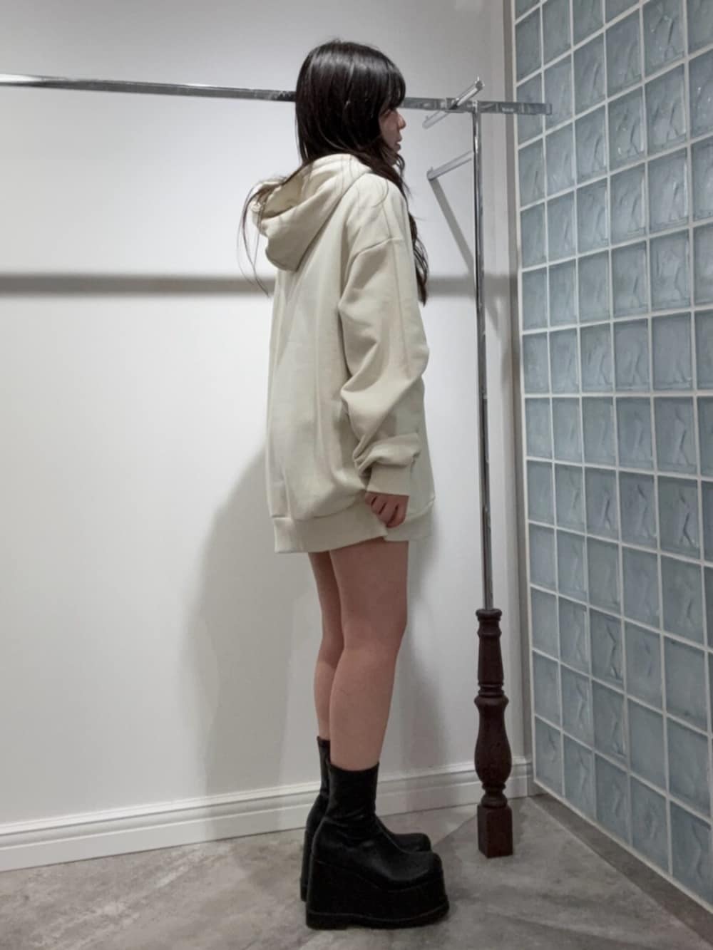 ブラック系のブーツ、ブルー系のデニムパンツ、ホワイト系のスウェットを着用したレディースの冬コーディネートの2枚目の写真