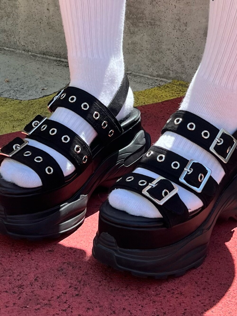 グレー系のジャンパースカート、ブラック系のサンダルを着用したレディースの春コーディネートの7枚目の写真