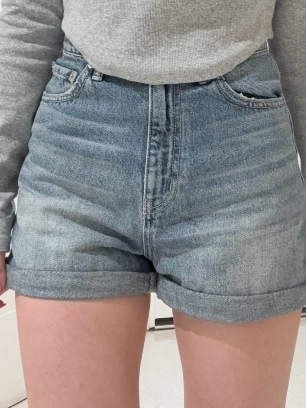 ブラック系のブーツ、ブルー系のデニムパンツ、ホワイト系のスウェットを着用したレディースの冬コーディネートの5枚目の写真