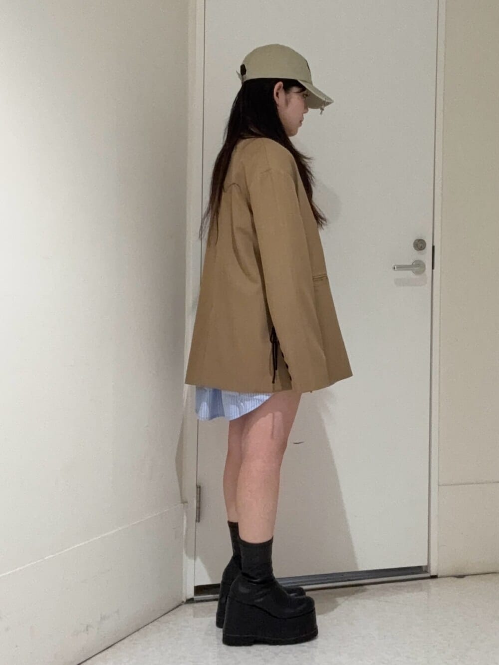 ブラック系のブーツ、ブラウン系のテーラードジャケット、ブルー系のシャツ/ブラウスを着用したレディースの春コーディネートの2枚目の写真