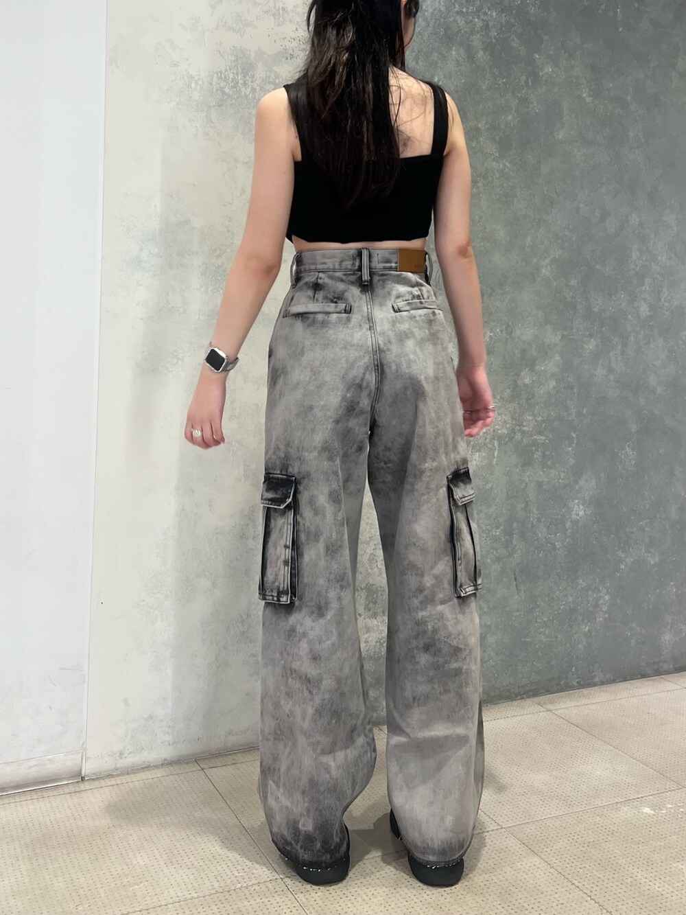 ブラック系のデニムパンツ、ブラック系のキャミソール、ブラック系のサンダルを着用したレディースの夏コーディネートの4枚目の写真