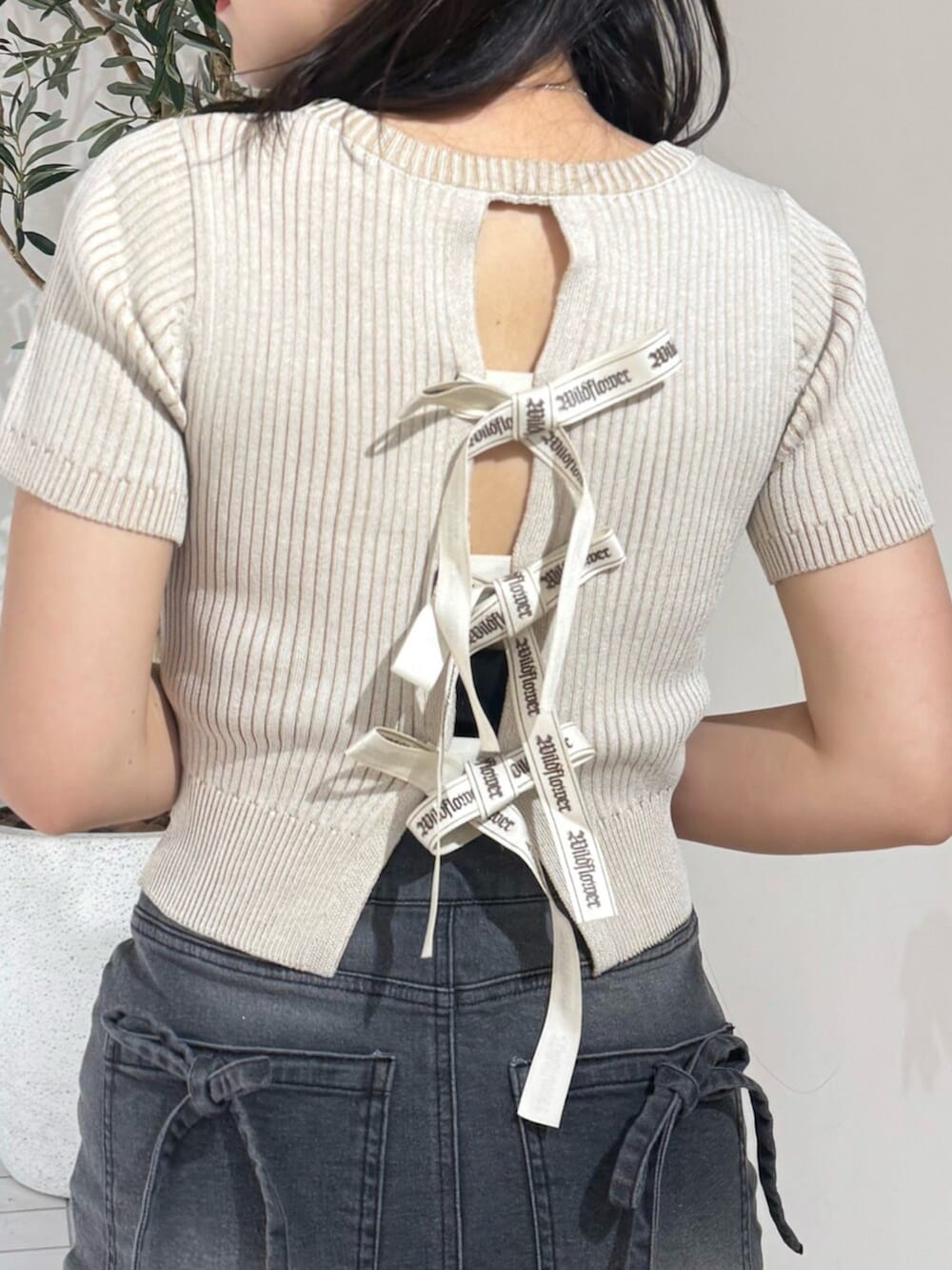 ブラック系のデニムスカート、ブラック系のサンダル、ベージュ系のニット/セーターを着用したレディースの夏コーディネートの4枚目の写真