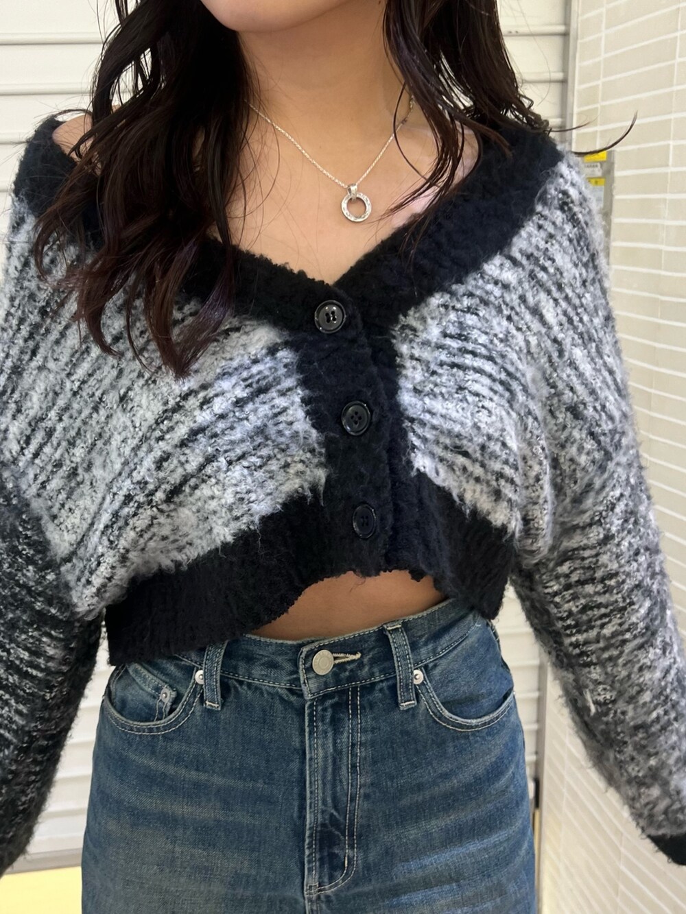 ブルー系のデニムパンツ、ブラック系のカーディガン/ボレロ、ブラック系のブーツを着用したレディースの冬コーディネートの7枚目の写真