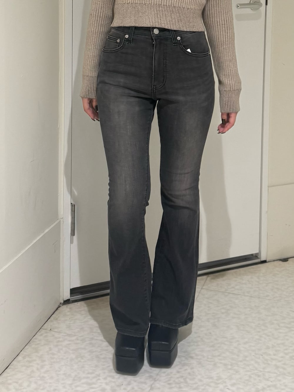 ブラック系のブーツ、ブラック系のデニムパンツ、ホワイト系のカーディガン/ボレロを着用したレディースの秋コーディネートの5枚目の写真