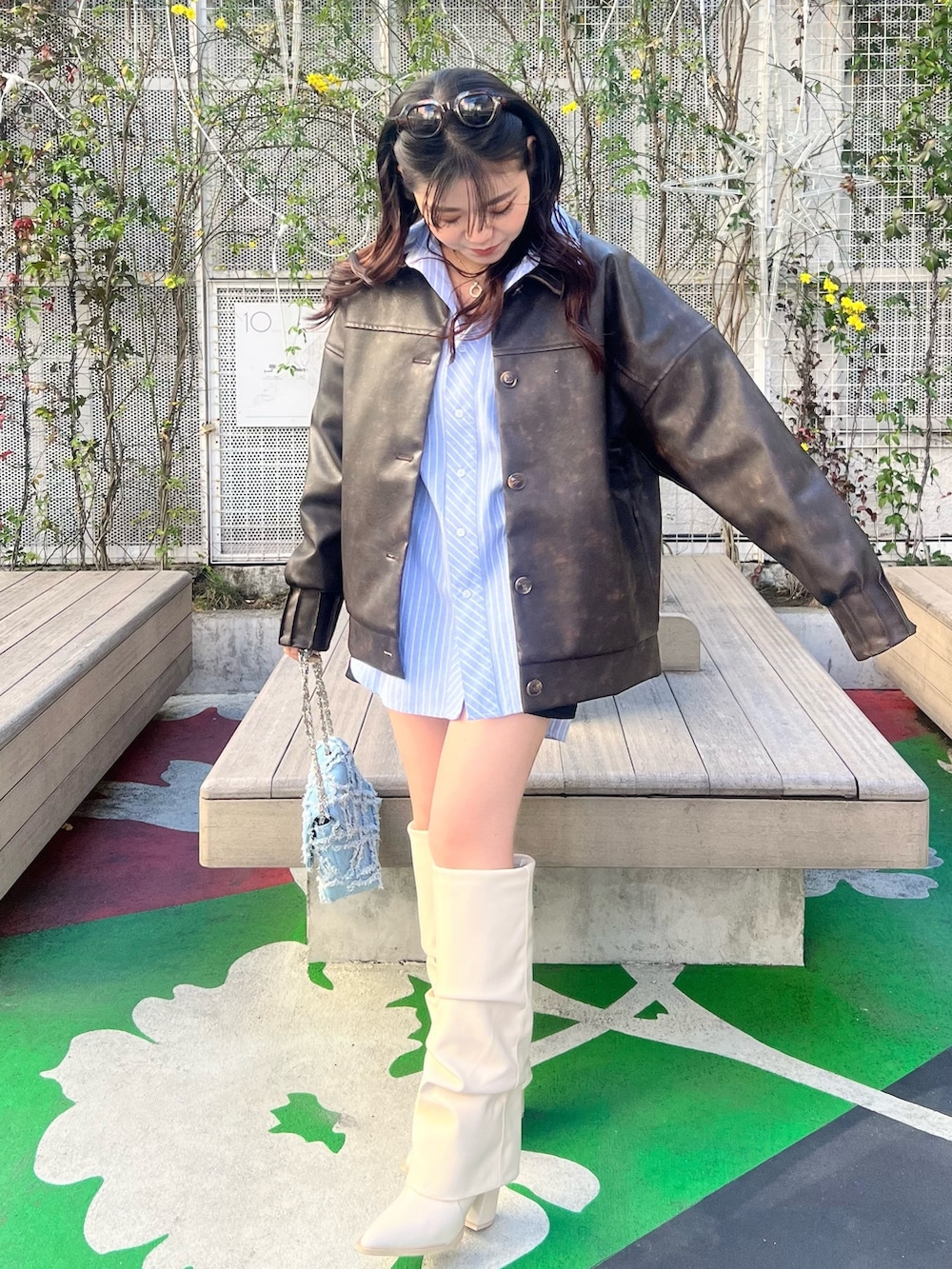 ホワイト系のブーツ、ブラウン系のブルゾン、ブルー系のシャツ/ブラウスを着用したレディースの春コーディネートの3枚目の写真