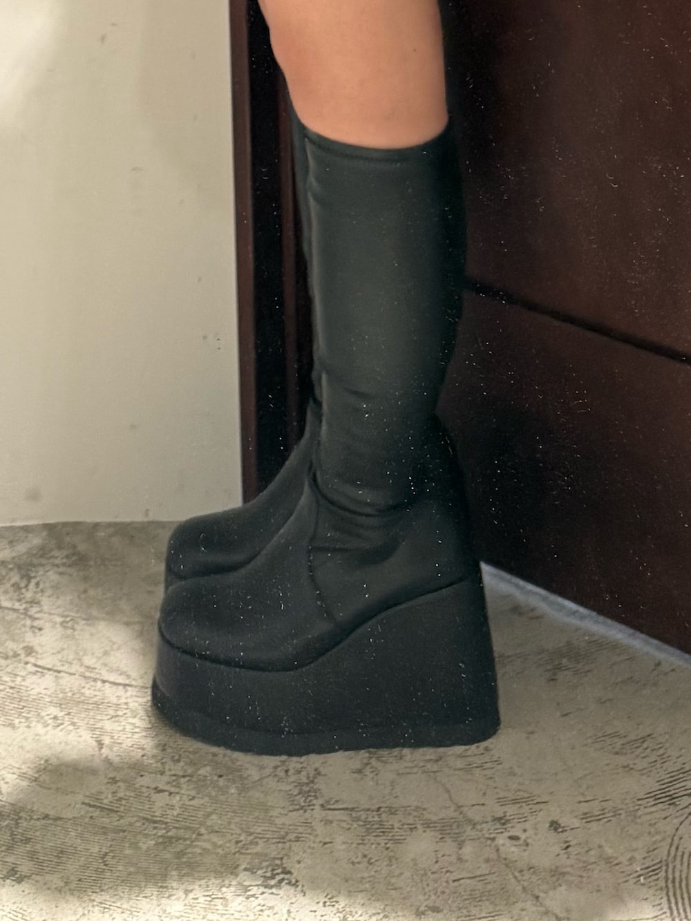 レッド系のワンピース、ブラック系のブーツを着用したレディースの秋コーディネートの6枚目の写真