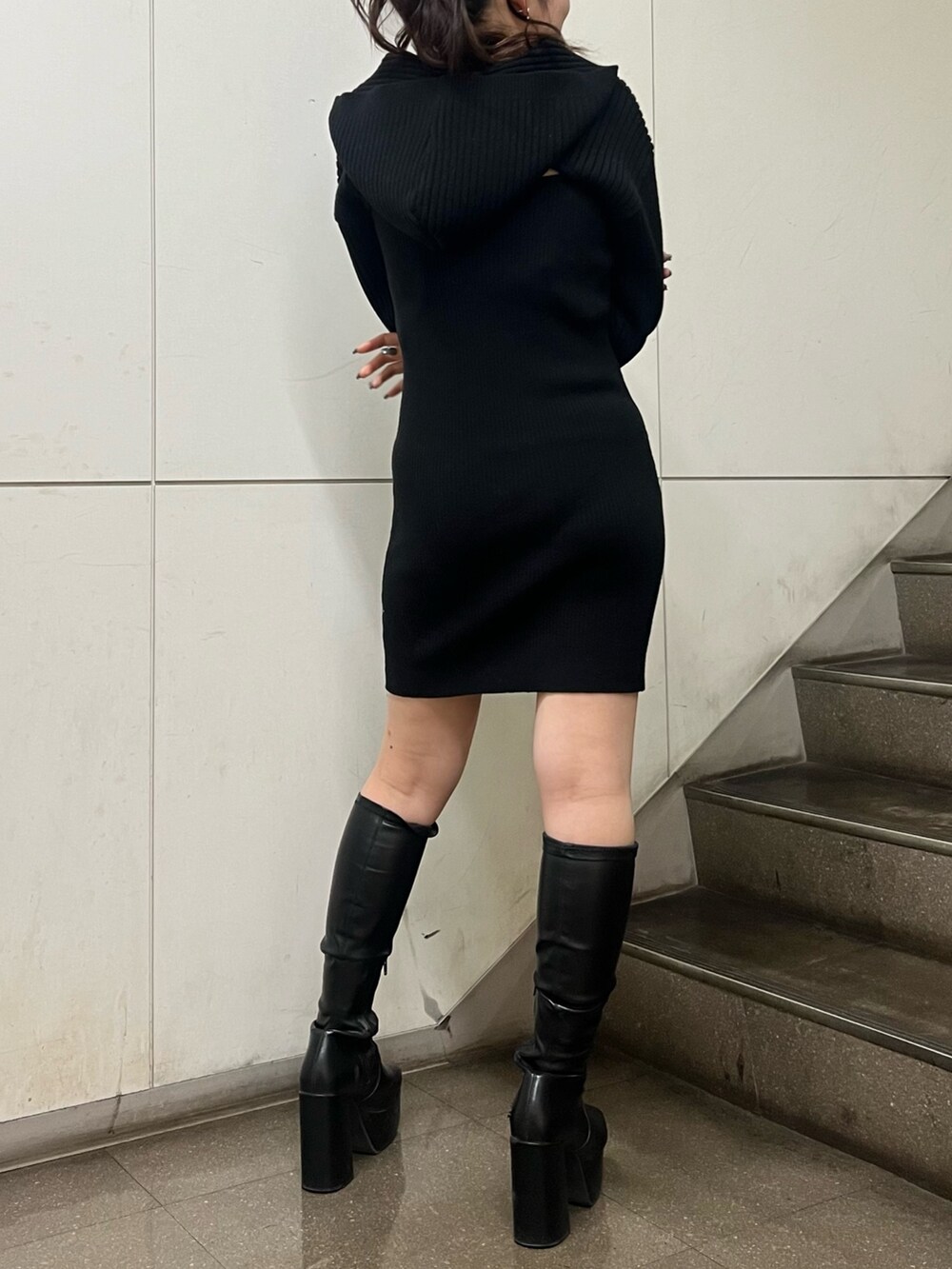 ブラック系のワンピース、ブラック系のブーツを着用したレディースの冬コーディネートの6枚目の写真