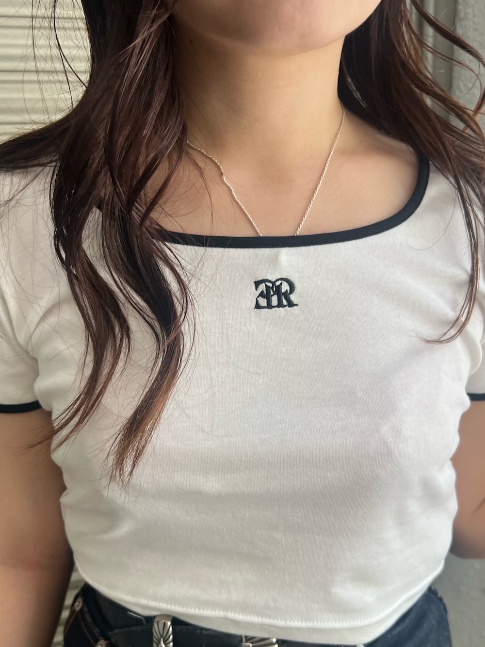 ブルー系のデニムパンツ、ホワイト系のTシャツ/カットソー、ブラック系のハンドバッグを着用したレディースの夏コーディネートの6枚目の写真